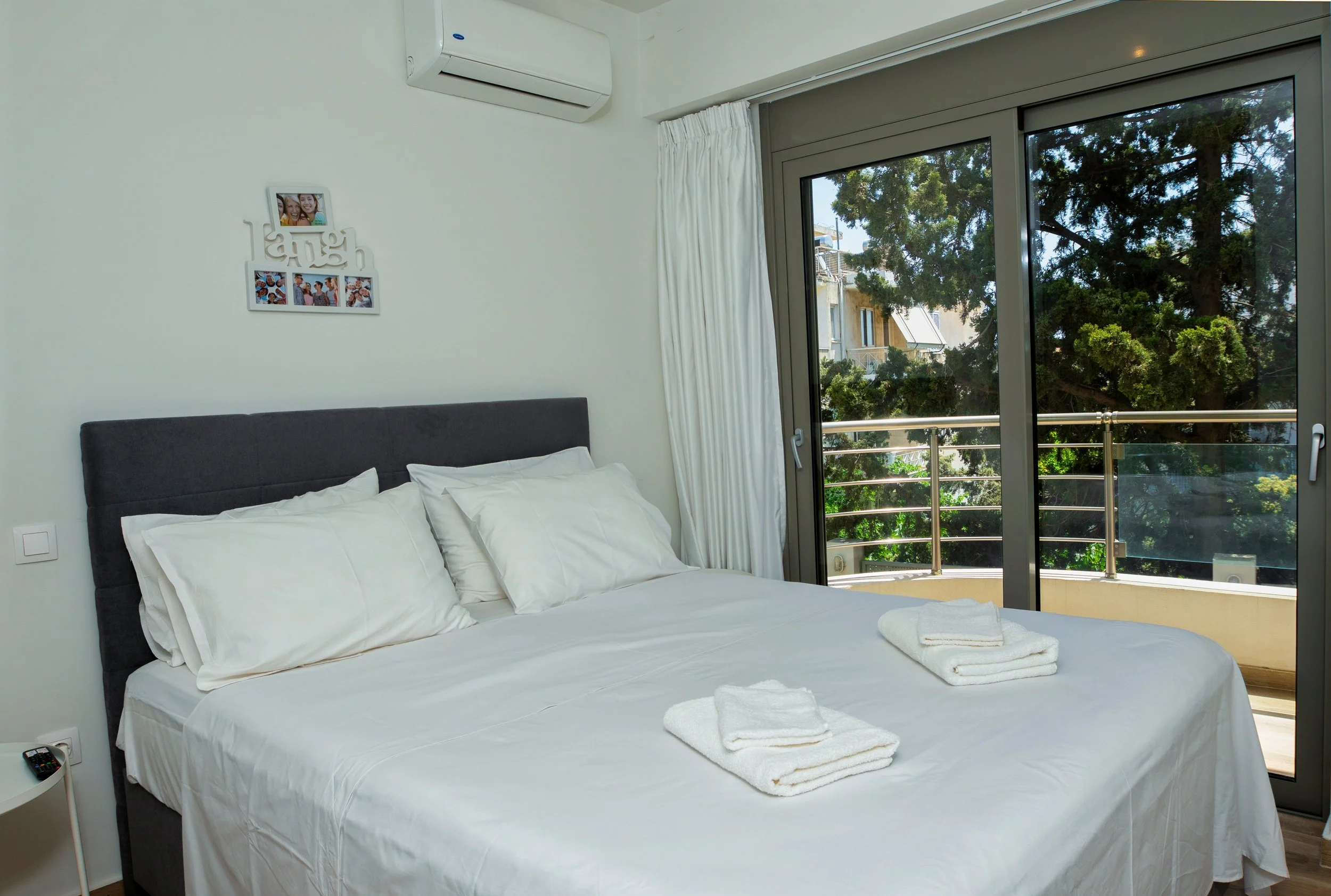 Primary bedroom — balcony view over trees