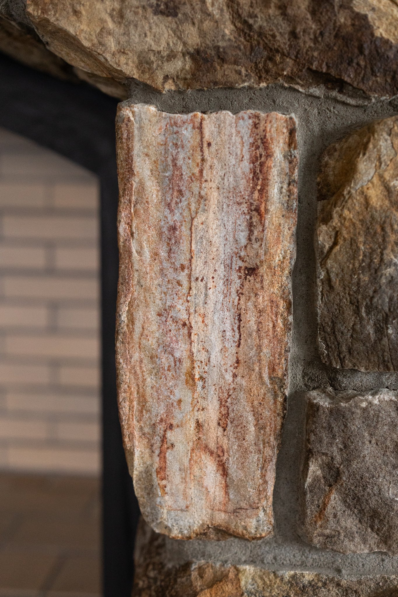 Close-up of a multicolored stone brick on a fireplace or wall.