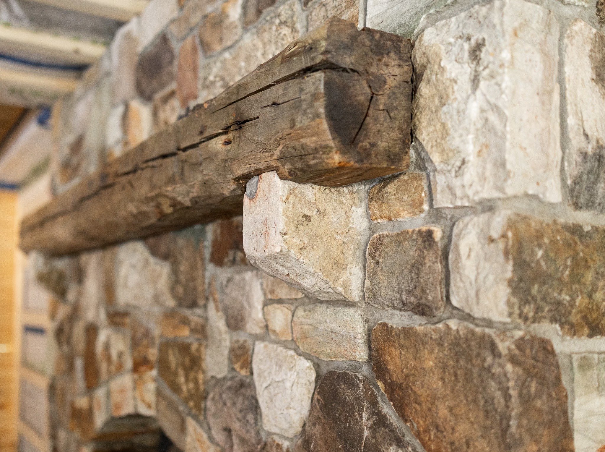 Close-up of a stone and wood fireplace mantel install-  Located in Churubusco, NY. 