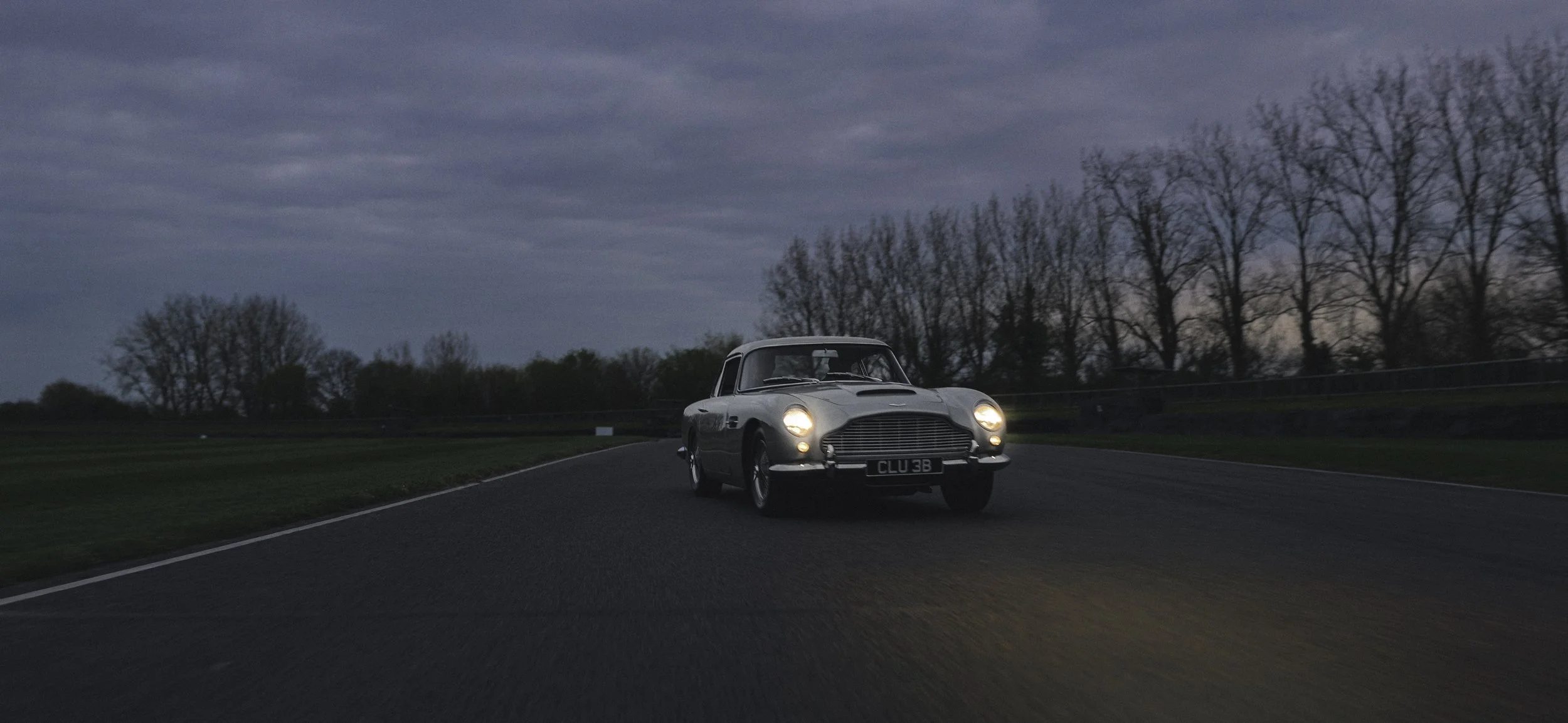 Aston Martin db5 on racetrack at night vintage car