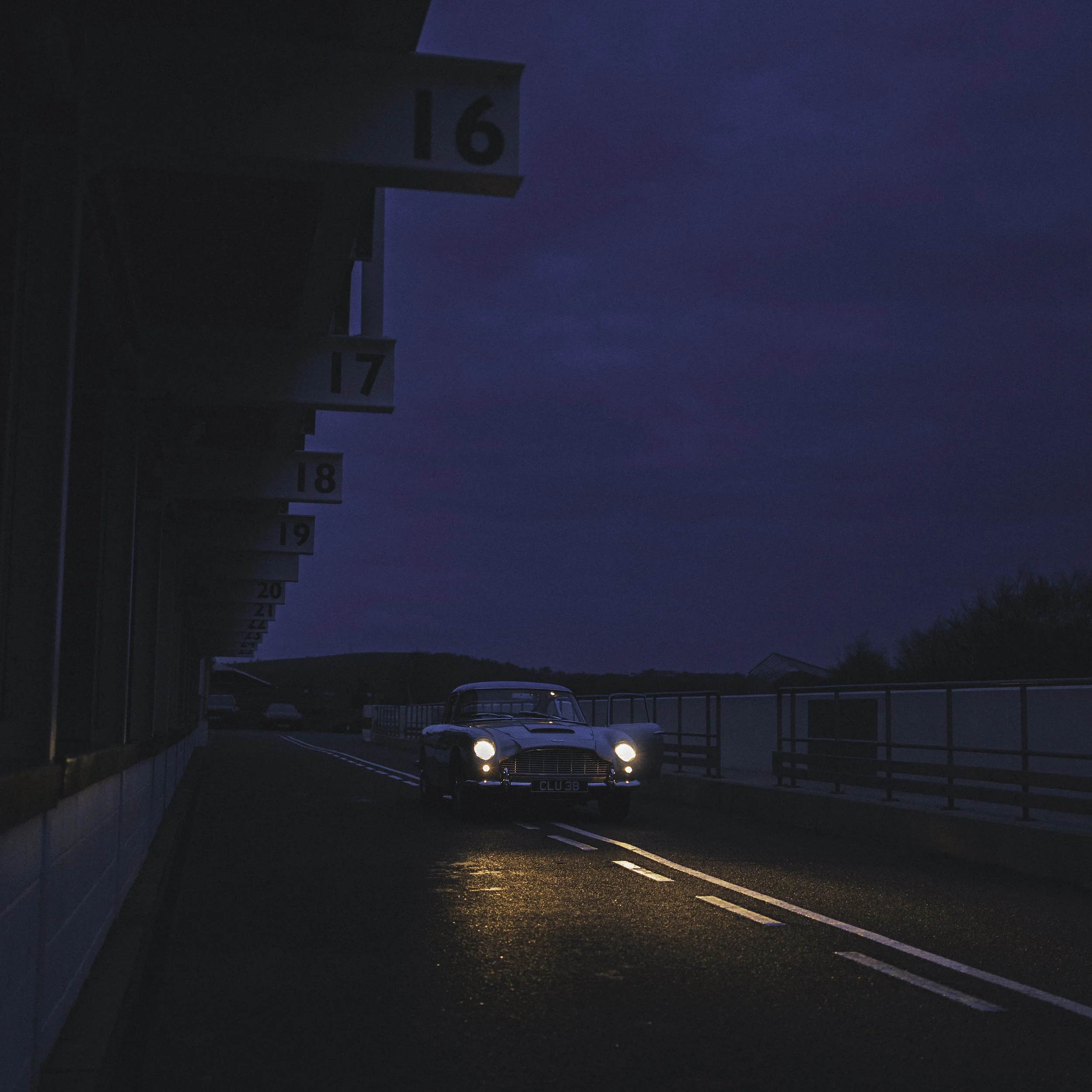 Aston Martin db5 vintage racing car in pit lane at night