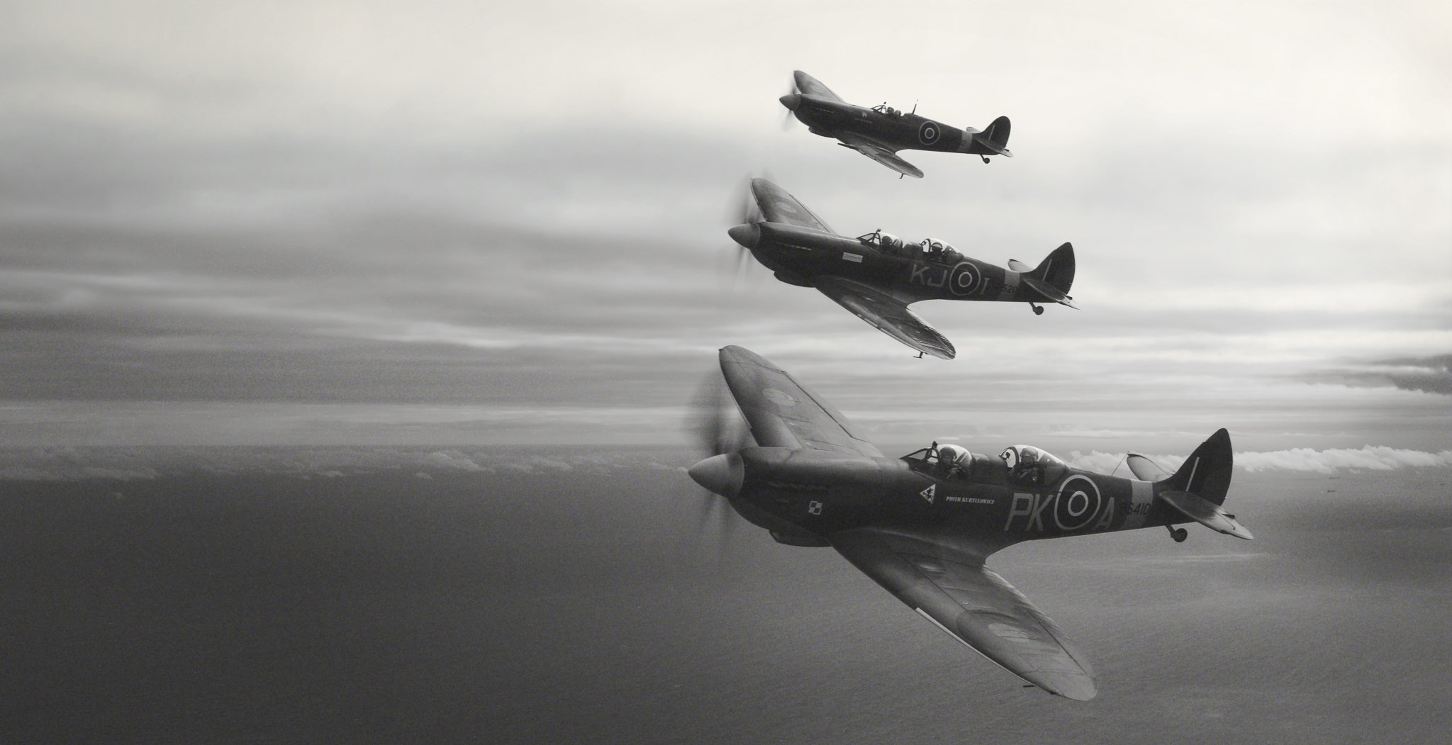 Three vintage fighter jets flying in close formation in a cloudy sky, captured in black and white.