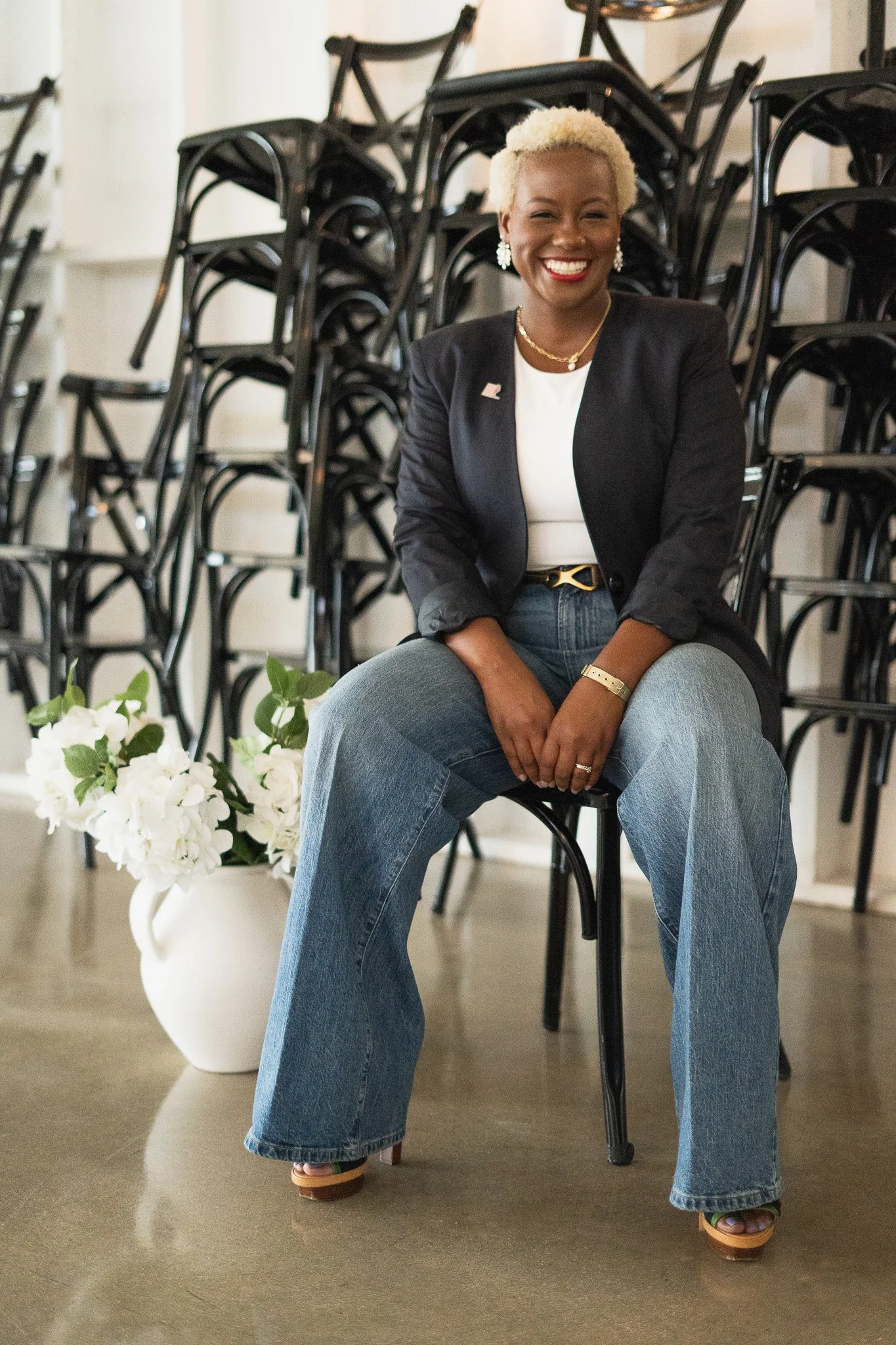 Professional black female sitting in chair. She is a wedding coordinator and corporate event planning consultant