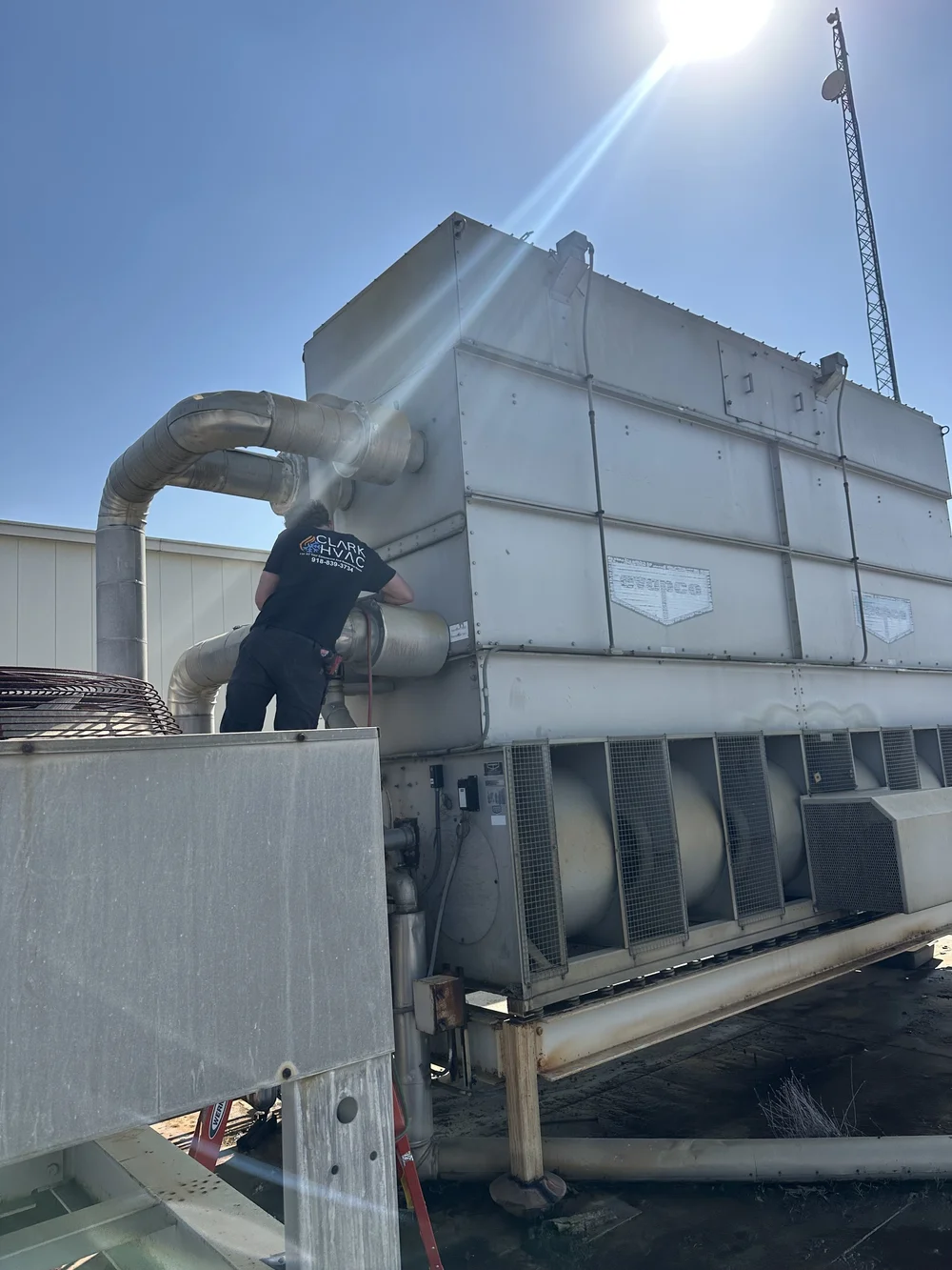 Clark HVAC technician servicing a commercial cooling tower