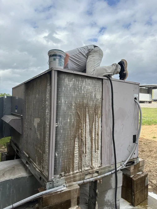 Clark HVAC technician servicing a commercial rooftop Carrier HVAC unit in Fort Smith, AR