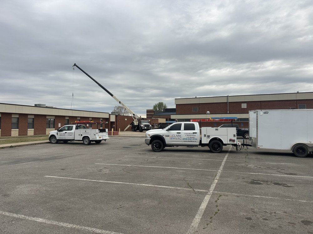 Crane setting a commercial rooftop HVAC unit on a school building for Clark HVAC
