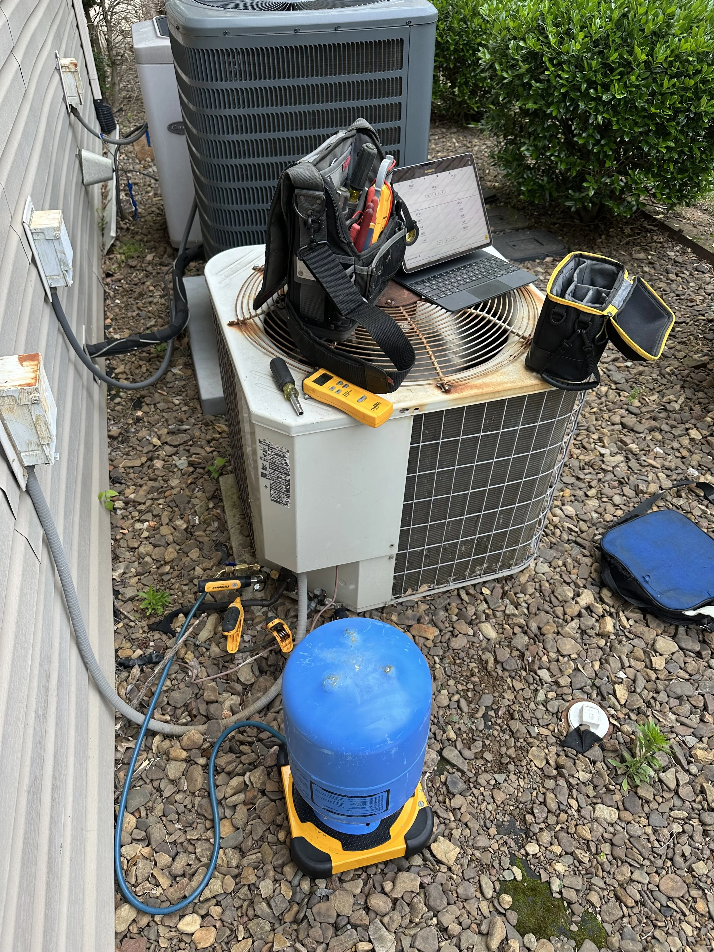 Local Clark HVAC technician performing emergency AC repair and diagnostics on an outdoor condenser unit to keep your home cool and comfortable.