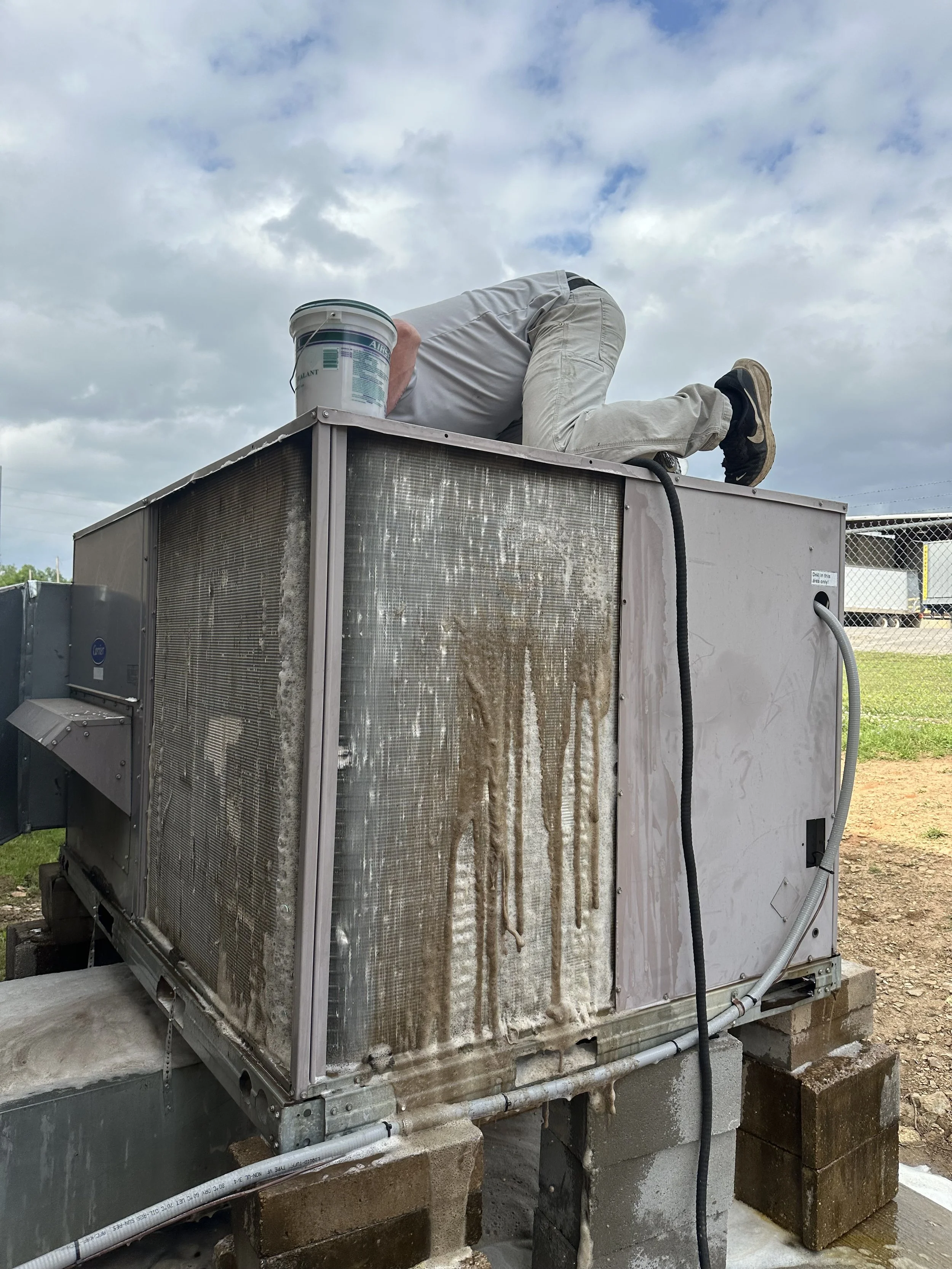 Clark HVAC technician diagnosing an outdoor AC condenser unit in Poteau, Oklahoma