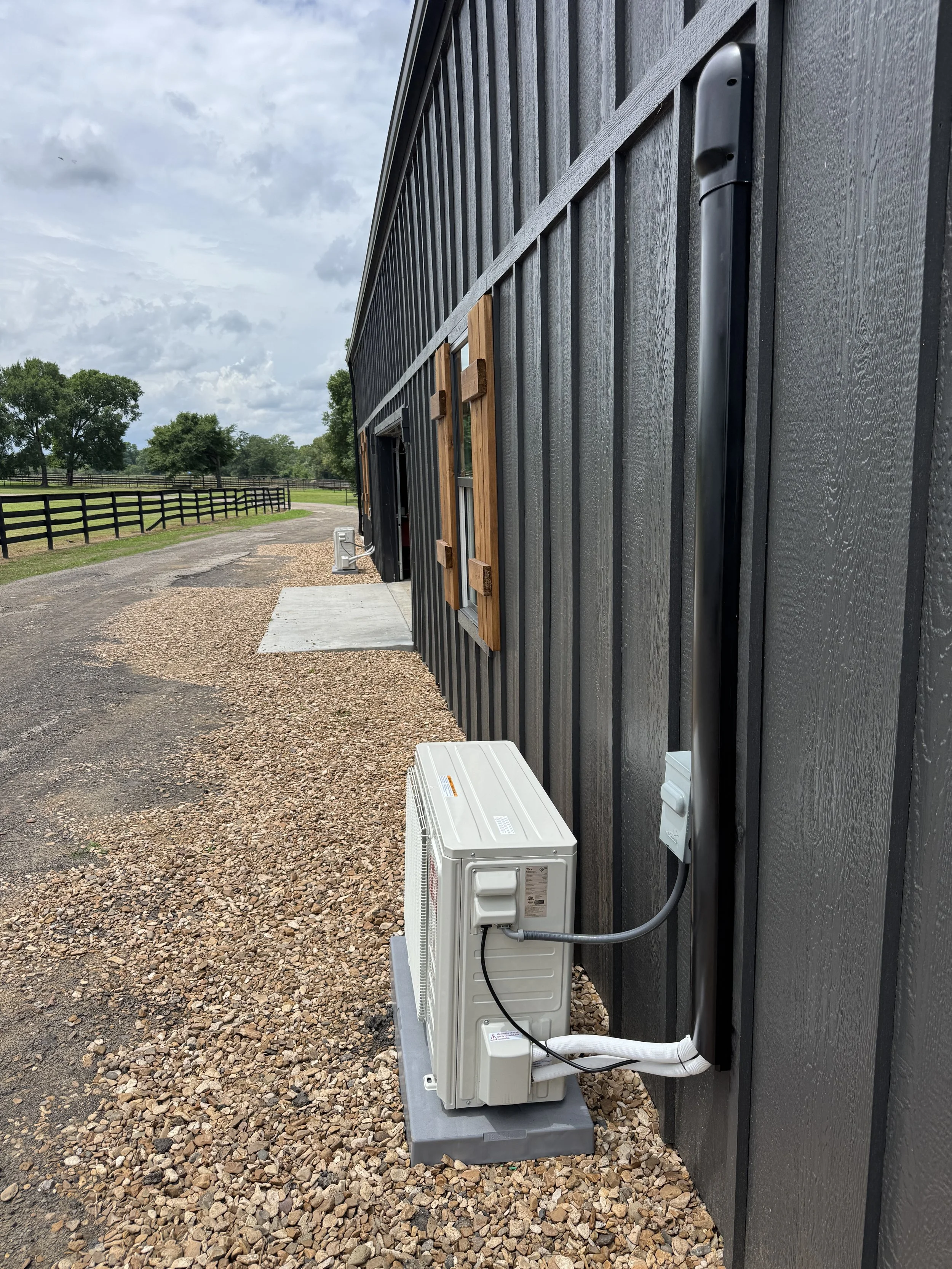 Clark HVAC professionally installed TCL ductless mini-split on a black barndominium with clean line set hide cover