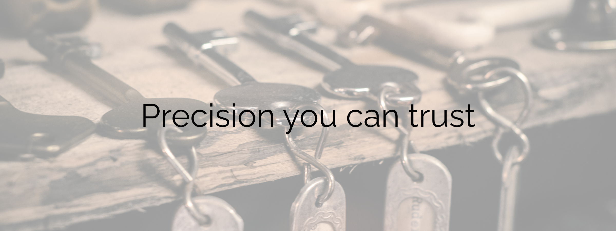 Close-up of metal keys and keychains with the text 'Precision you can trust' overlaid.