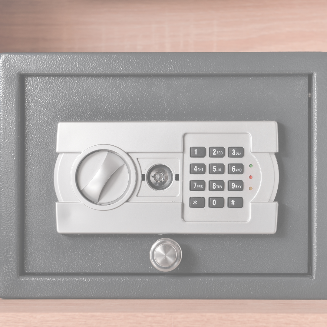 A black safe with a digital keypad and a keyhole, placed on a wooden surface.