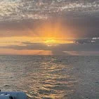 Sunset over the ocean with clouds in the sky