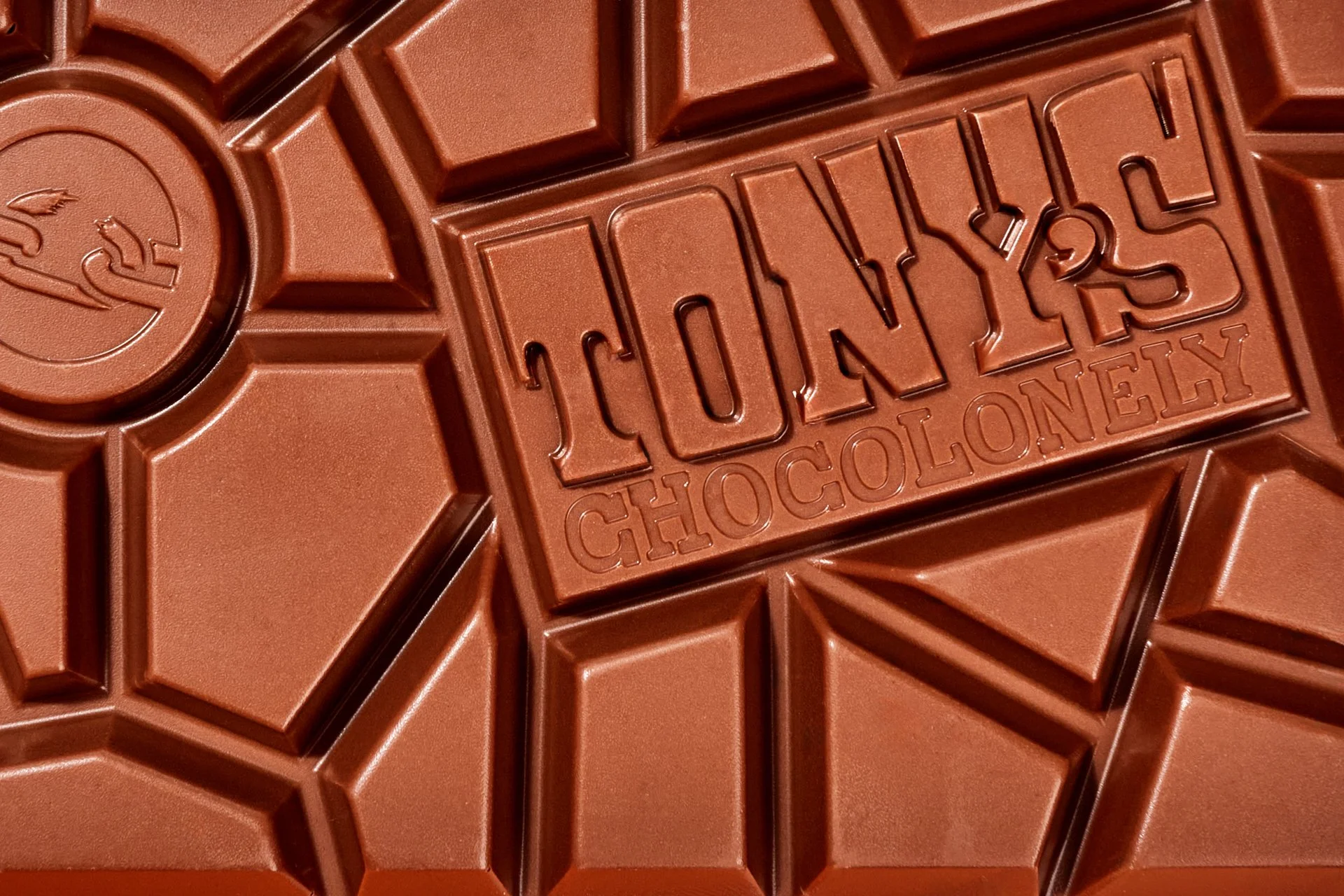 Close-up of a chocolate bar with the words 'LOYALTY CHOCOLONY' embossed on it, divided into geometric segments.