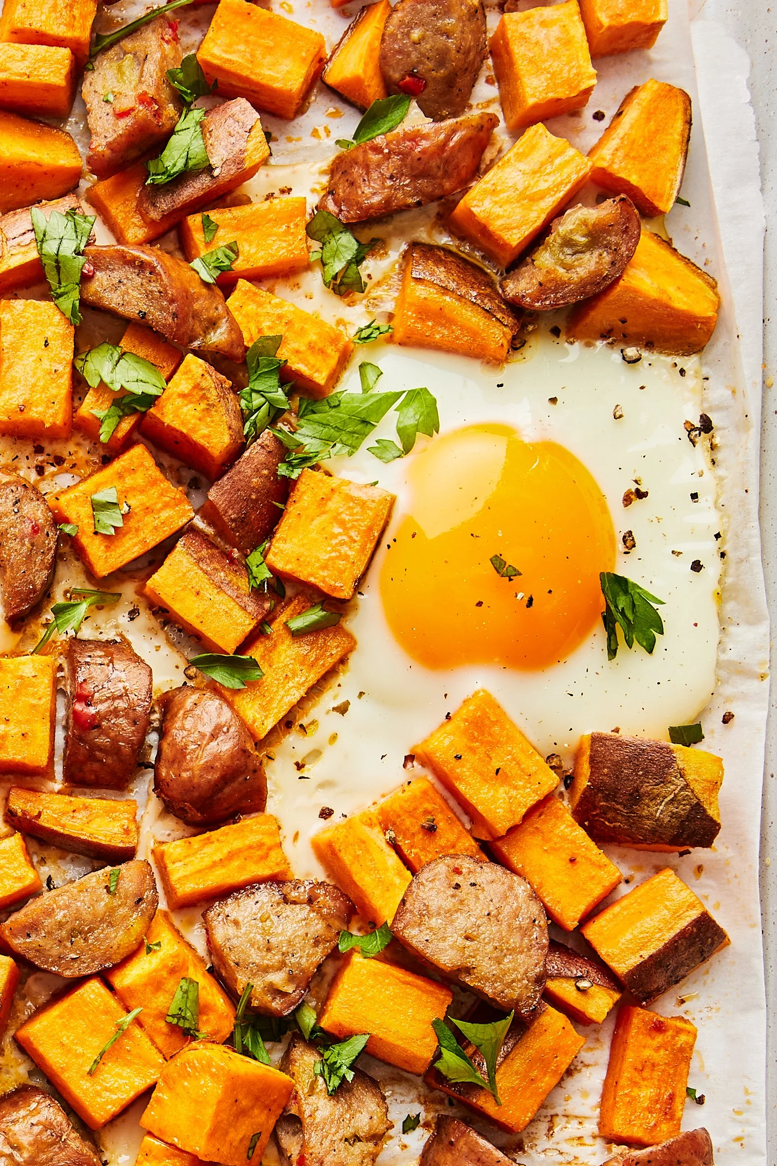 Sweet potato, sausage, and parsley with a cooked egg.
