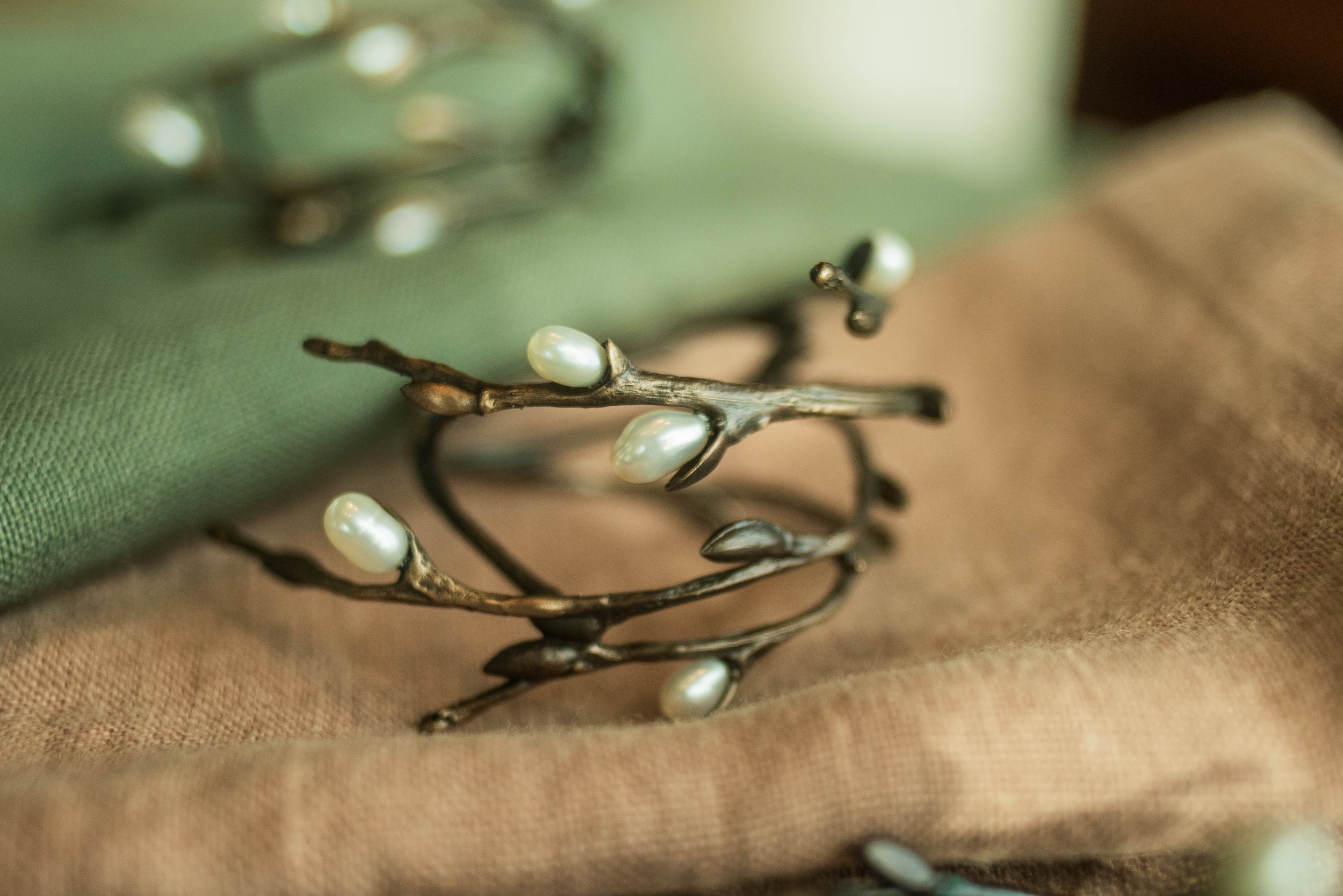 Closeup showcasing the antique brass finish and freshwater pearls incorporated in the timeless elegance of the Pussy Willow Napkin Rings