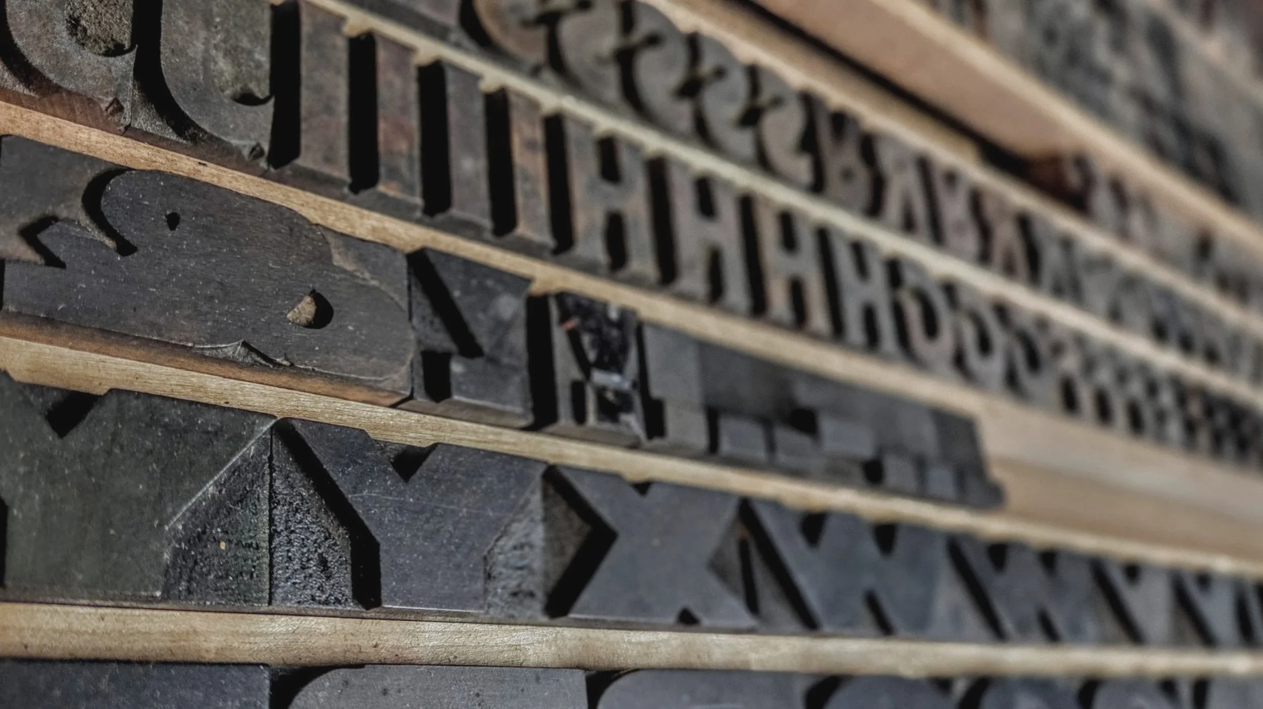 Close-up of vintage printing letterpress blocks stacked horizontally.