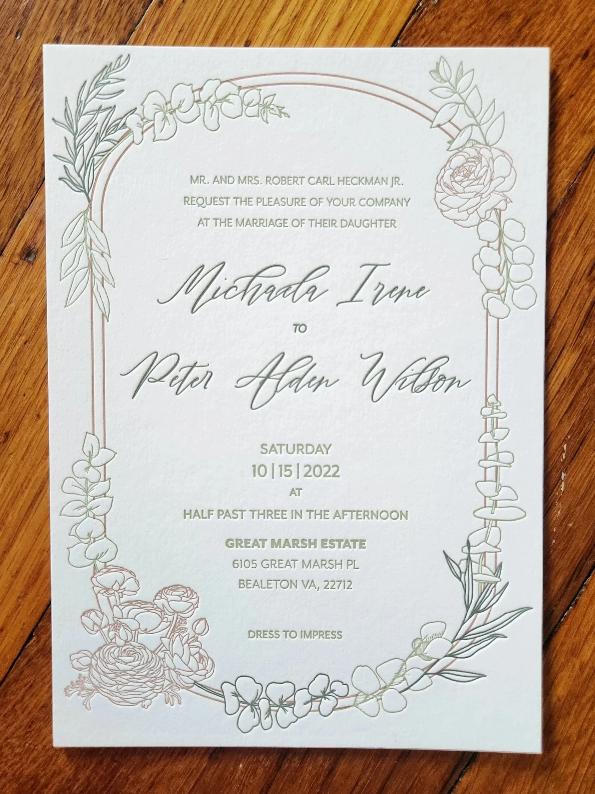 Wedding invitation with a floral border, wedding details, and names Michala Irene and Peter Adam Wilson.