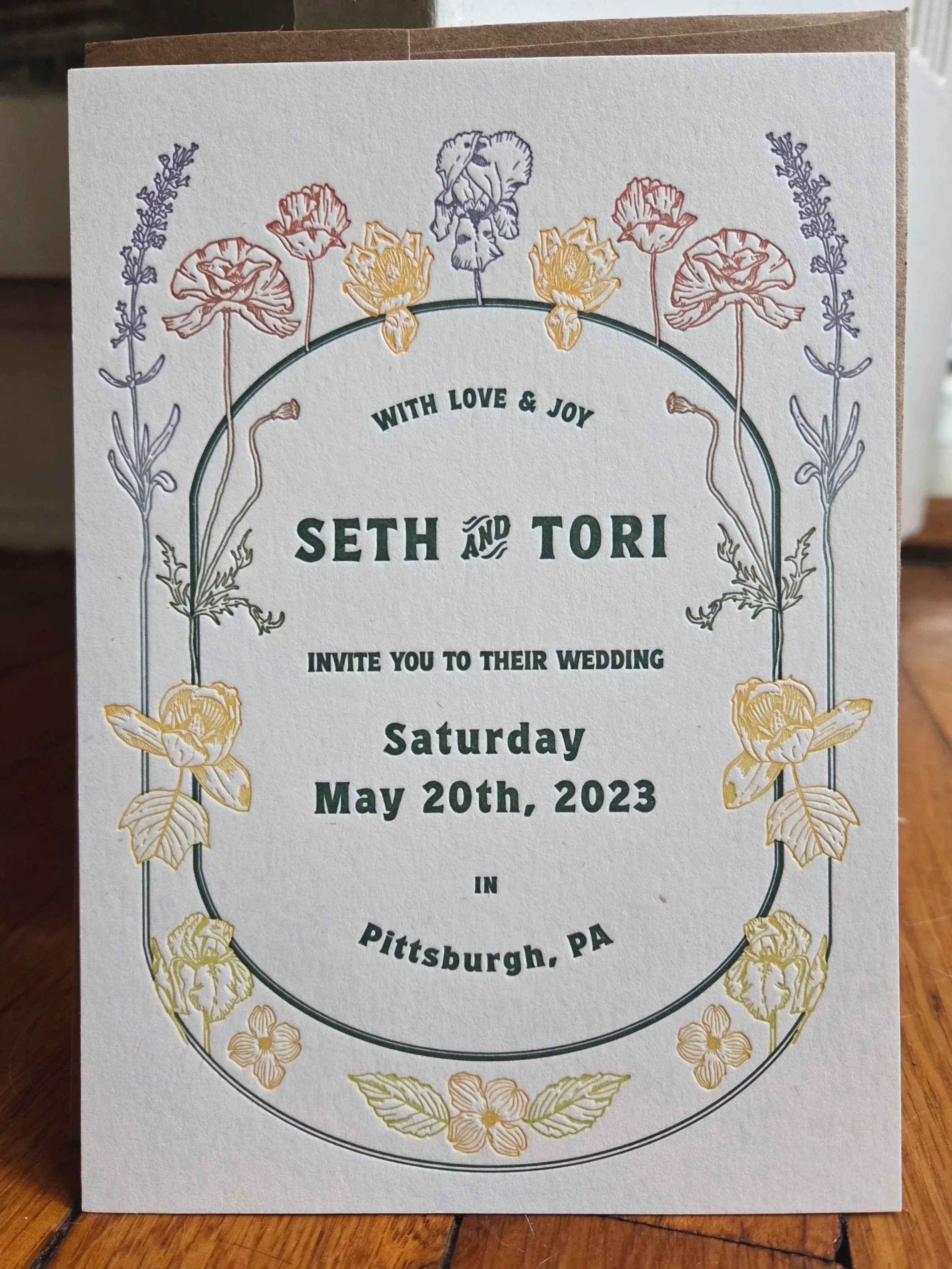 Wedding invitation with floral border, text reads: 'With Love & Joy, Seth and Tori invite you to their wedding, Saturday, May 20th, 2023 in Pittsburgh, PA.'