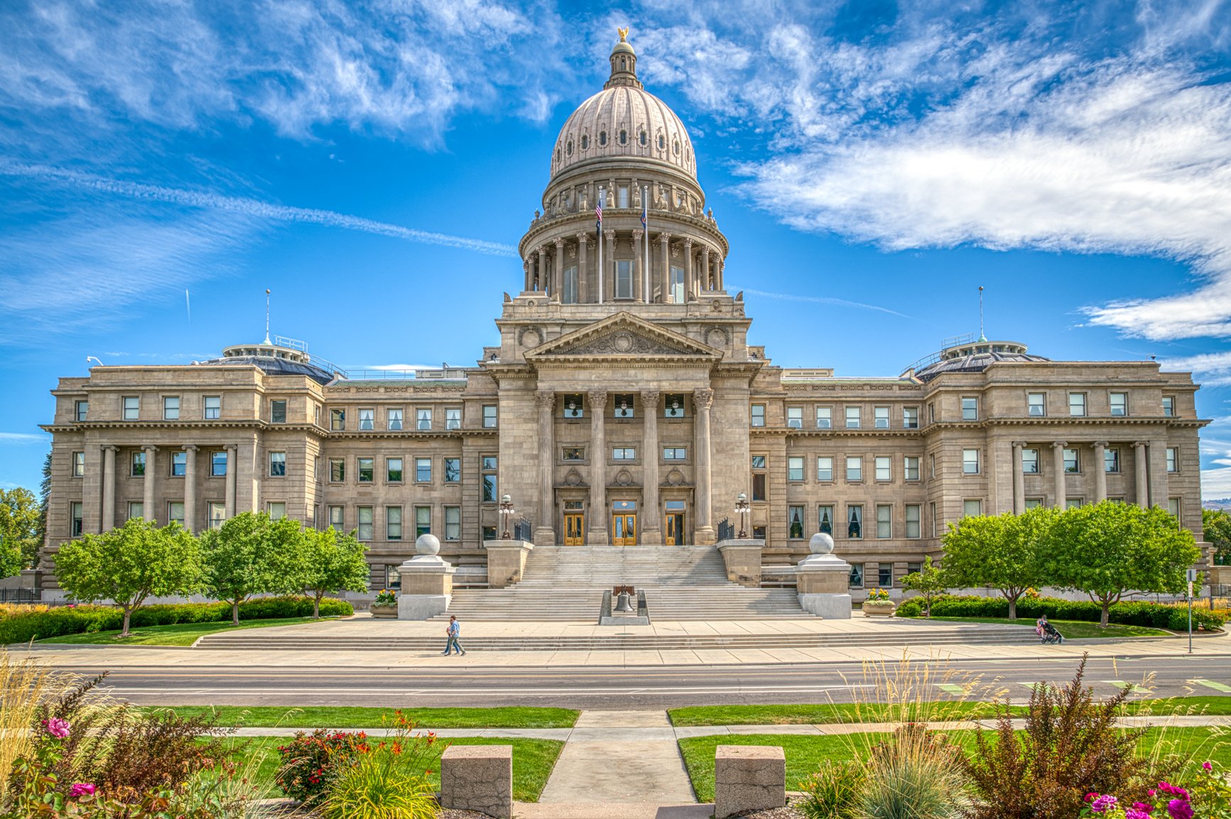 Standing proudly in the heart of Boise, the Idaho State Capitol rises beneath a brilliant blue sky, its stately dome and classical symmetry reflecting the strength and heritage of the Gem State. Manicured grounds, broad steps, and balanced architectu