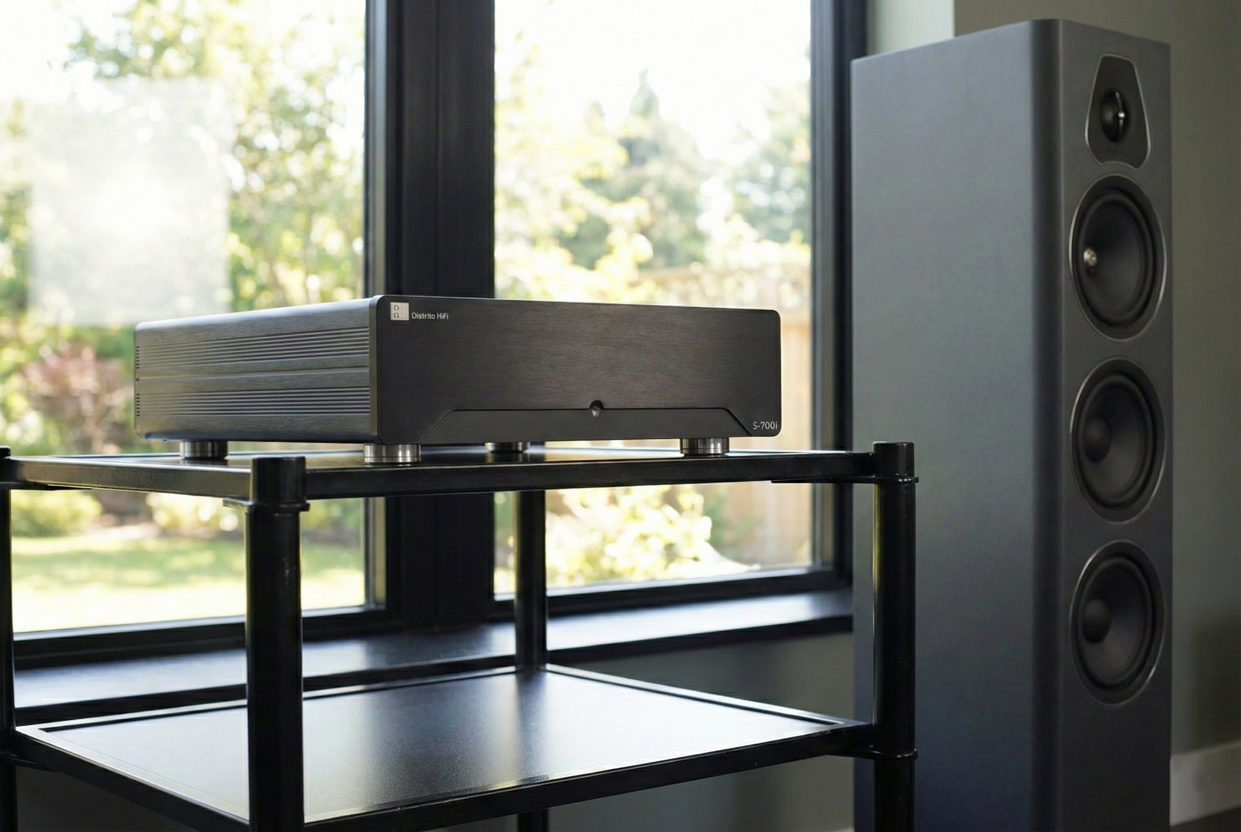 Altavoz grande de emisora en una habitación con vista a árboles y cielo a través de la ventana.