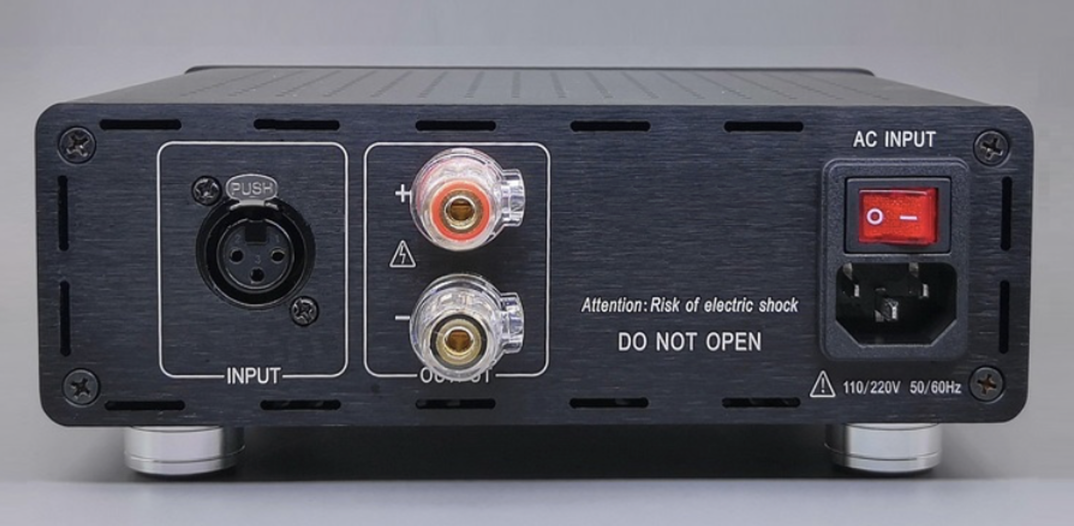 Parte trasera de un equipo electrónico con entradas y un interruptor de encendido, incluyendo un conector XLR, terminales de par de auriculares y puertos para entrada de corriente.