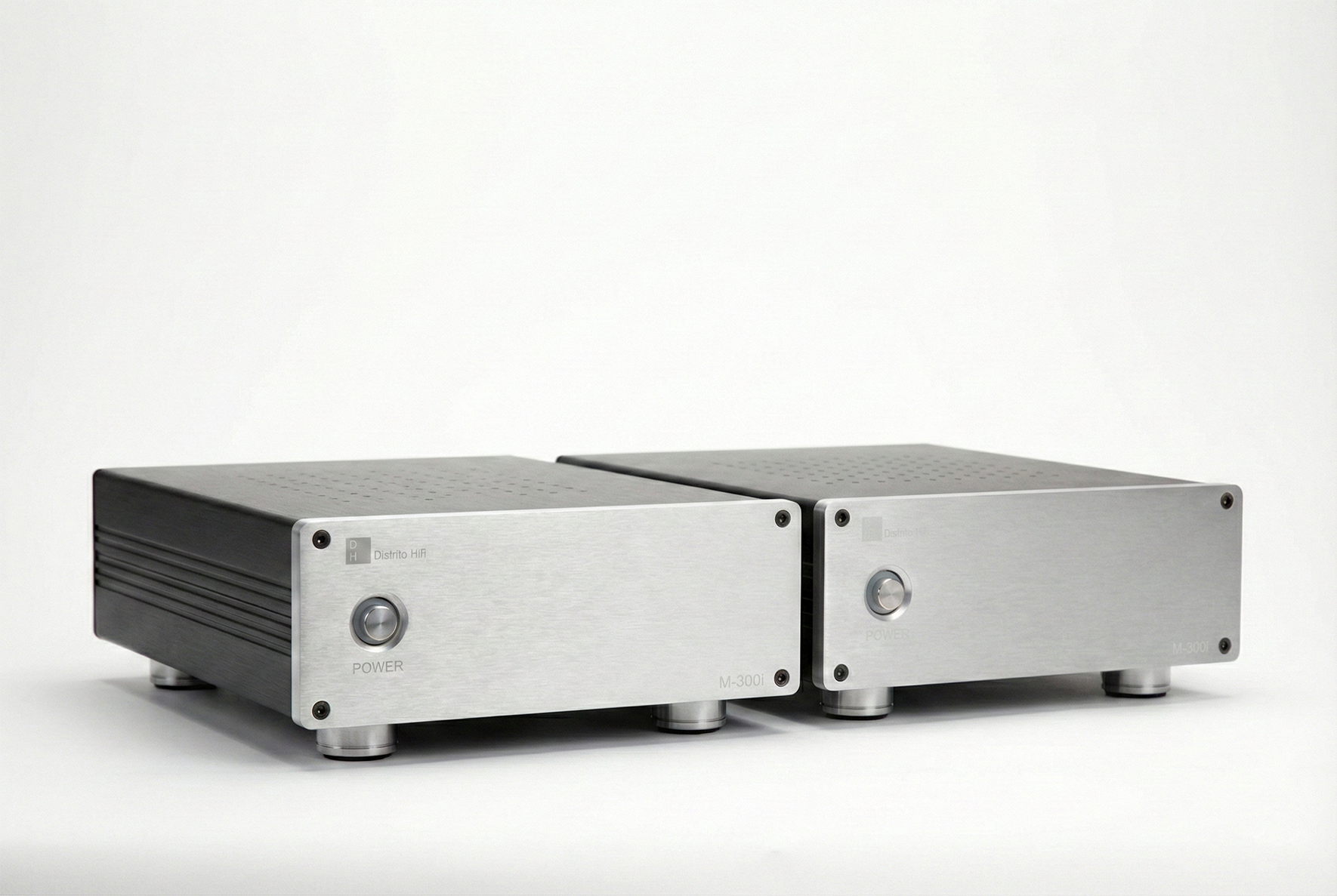 Dos amplificadores de audio de estilo tecnológico, de color plateado y diseño moderno, colocados sobre una superficie blanca.