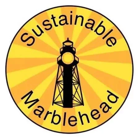 A circular logo with a yellow background and orange rays, featuring a black tower in the center. The words "Sustainable Marblehead" are curved around the top and bottom edges of the circle.