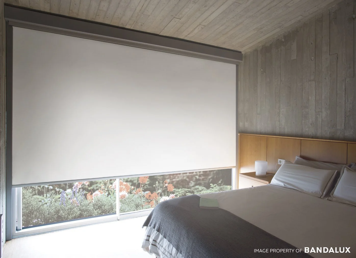Roller blind with box installed indoor in a modern design bedroom.