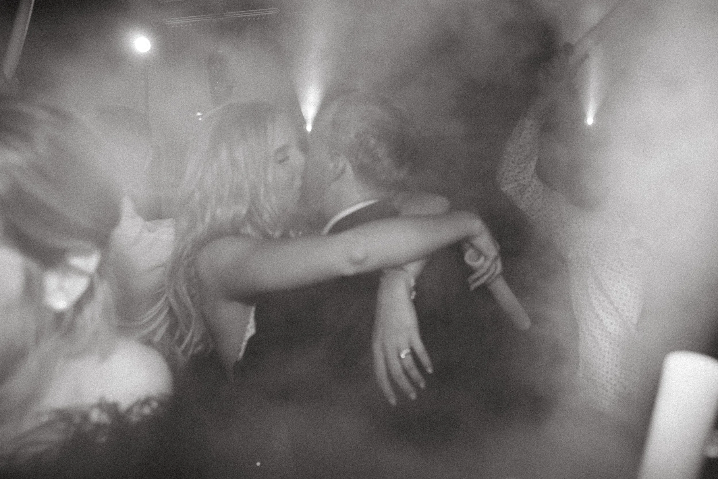 Black and white photo of people dancing in a smoky atmosphere