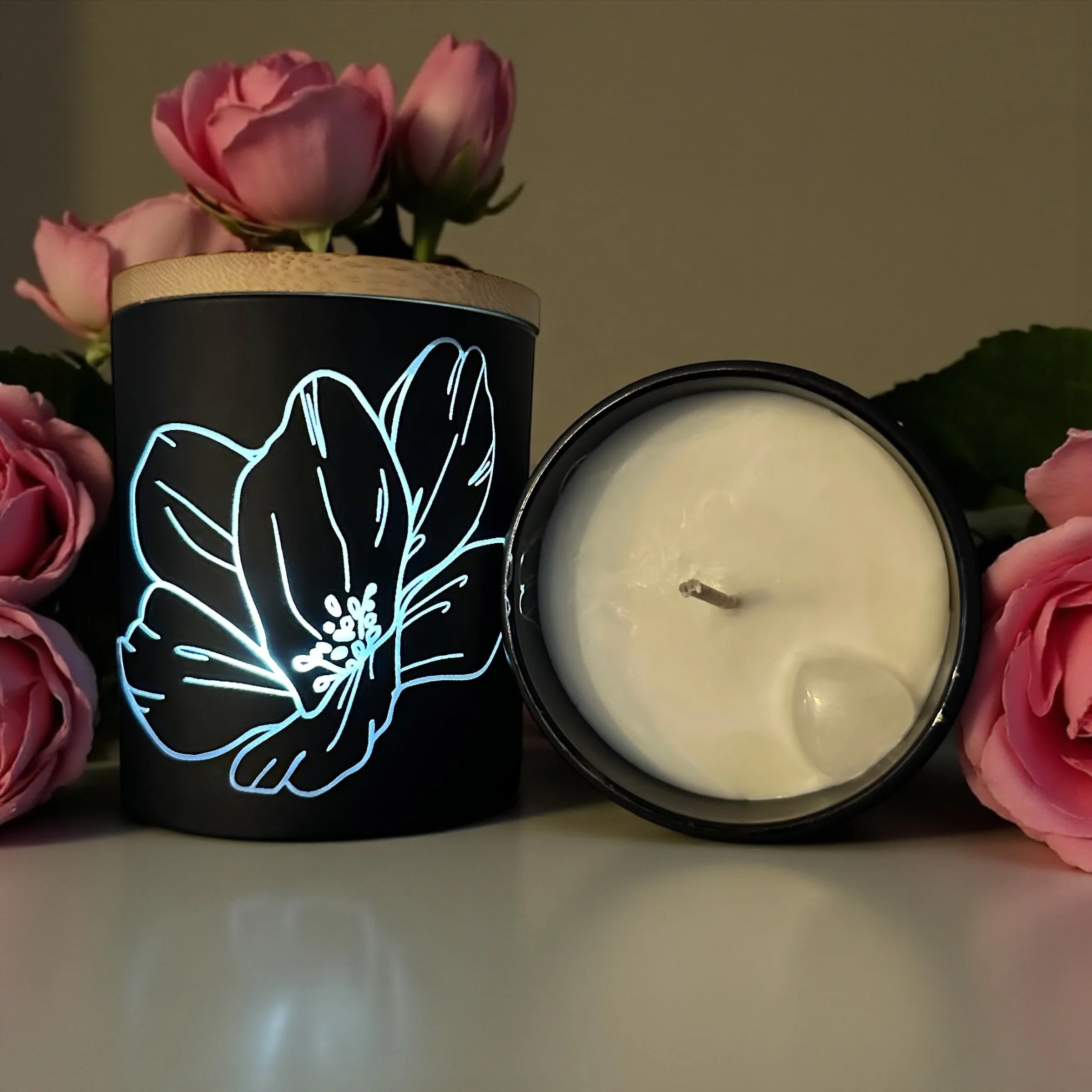 Blushing Bloom engraved candle, 11 oz jar, with a floral design, surrounded by pink roses.