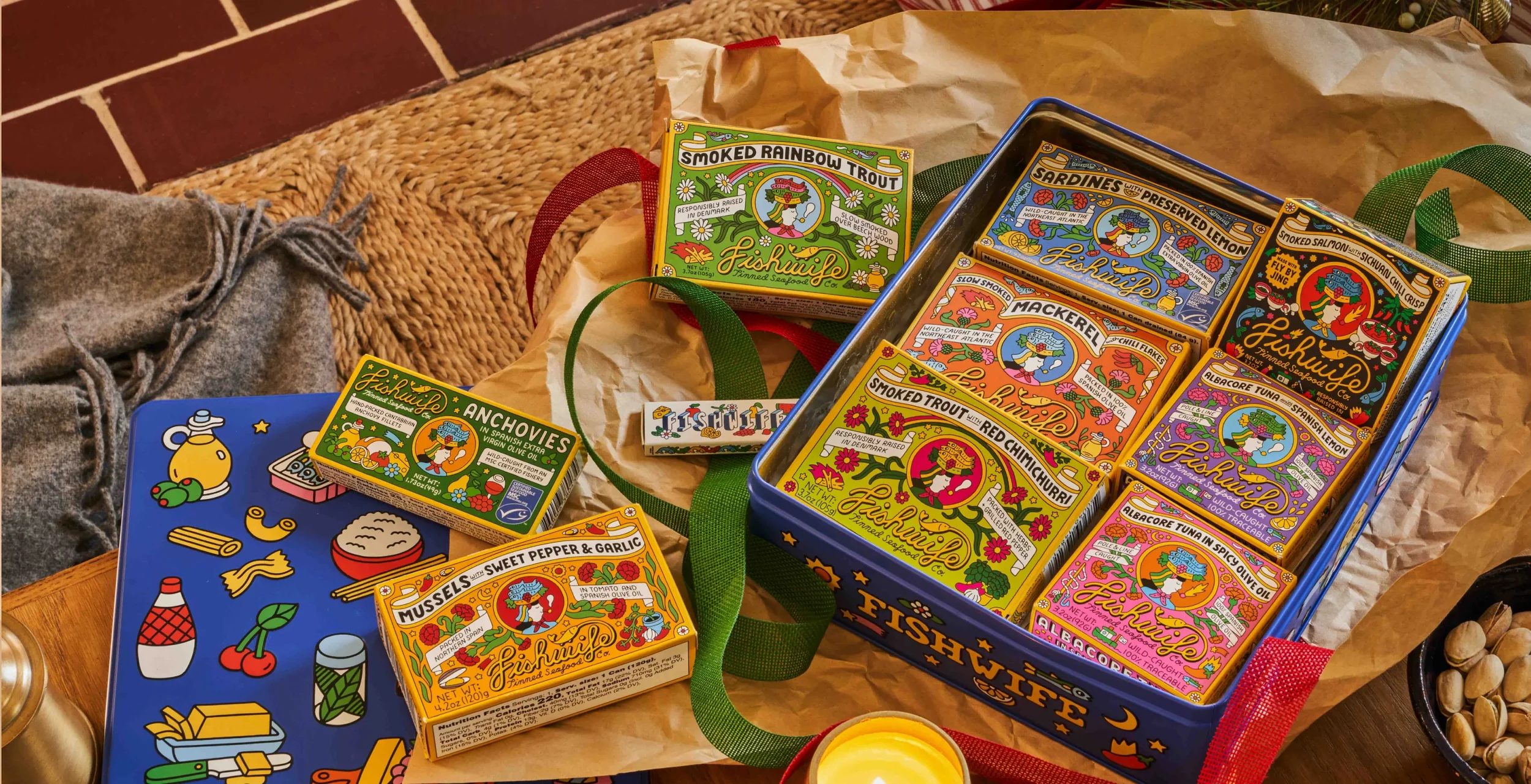 Colorful Japanese seafood gift boxes with illustrations of fish, shells, and marine life, set on a table.