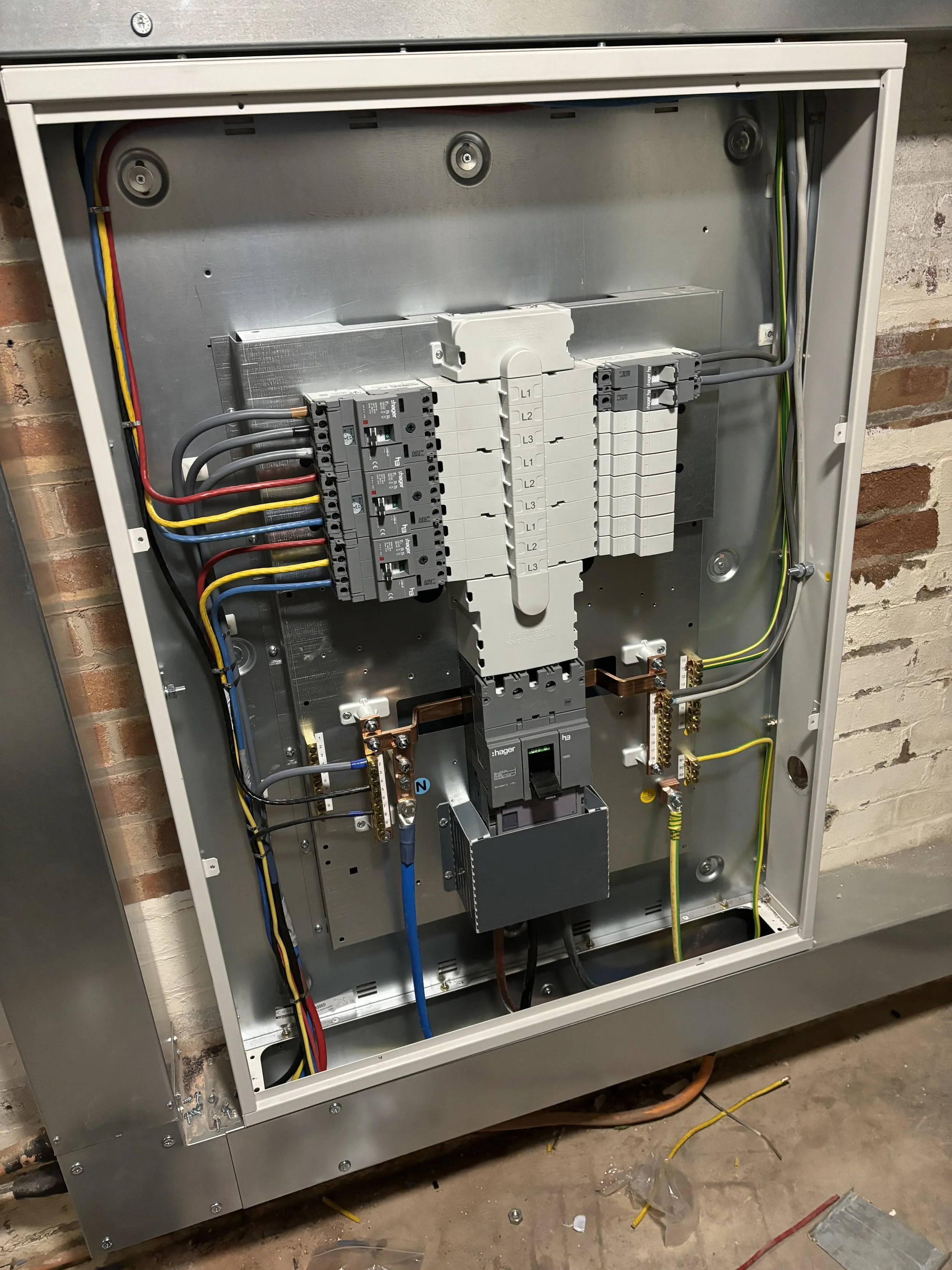 Open electrical control panel with wiring and circuit breakers inside.