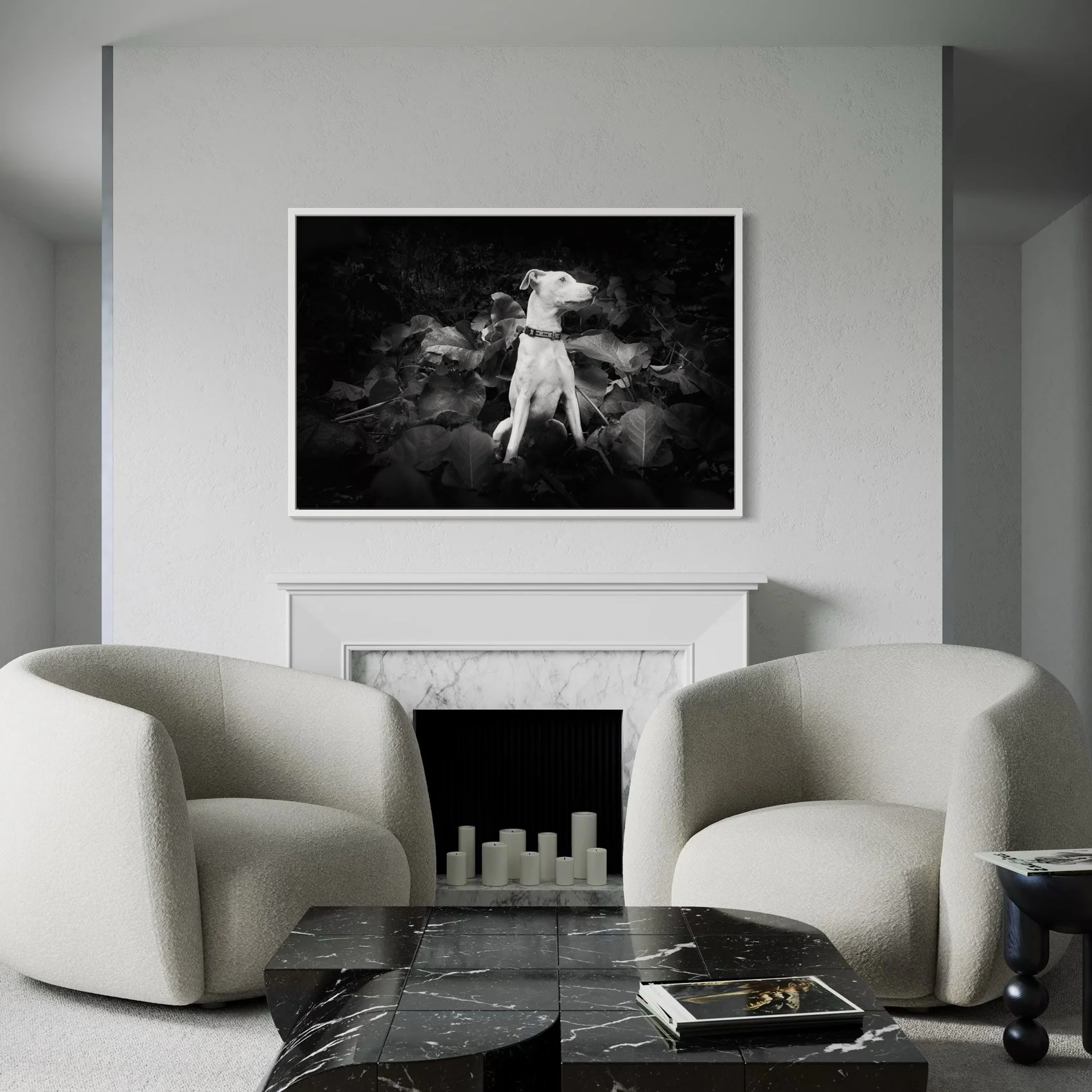 Black and white photograph of a dog sitting among dark foliage, mounted on a white wall in a modern living room.