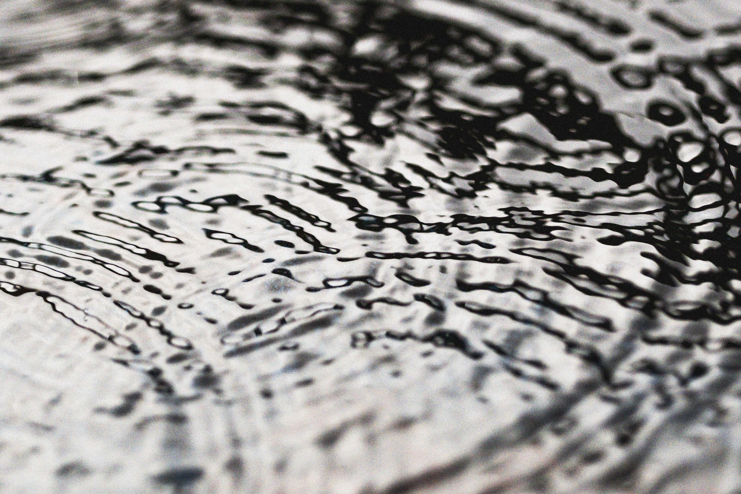 Close-up image of rippling water with black and white patterns.