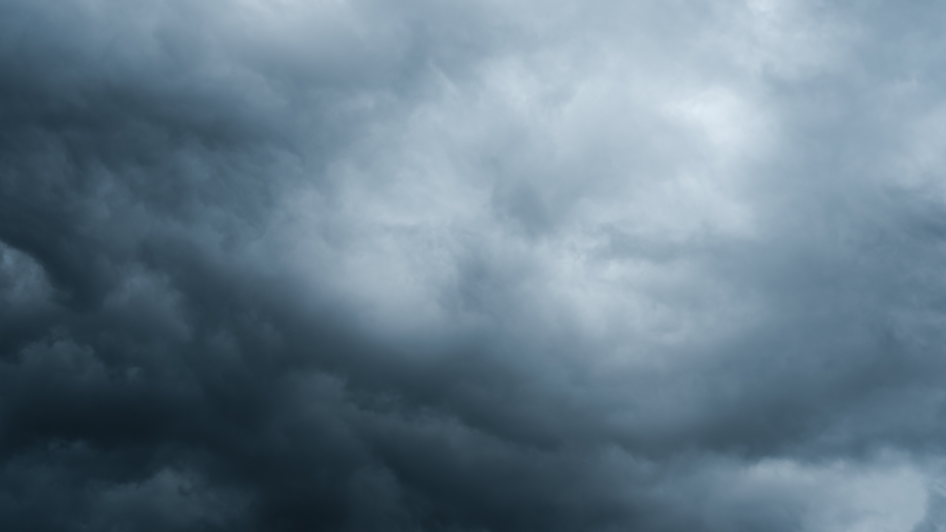 A dark grey cloud covering the entire image, with some lighter grey regions towards the top.