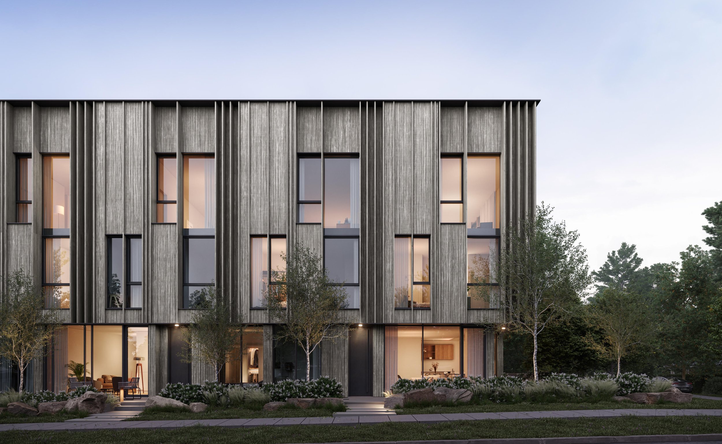 Modern townhouse with vertical siding and large windows, surrounded by trees and a landscaped garden, set against a clear sky, set in Vancouver Westside.