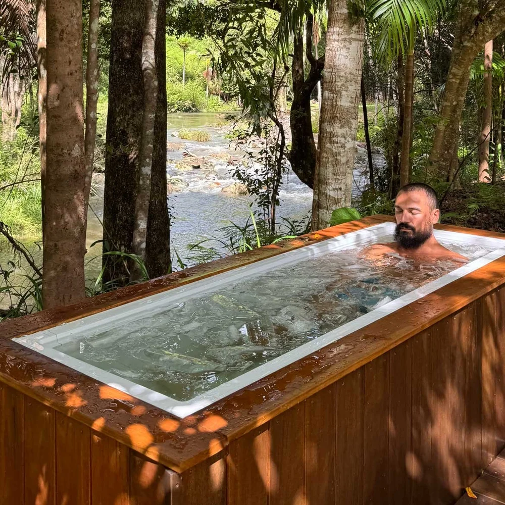A guest in the cold plunge beside the sauna