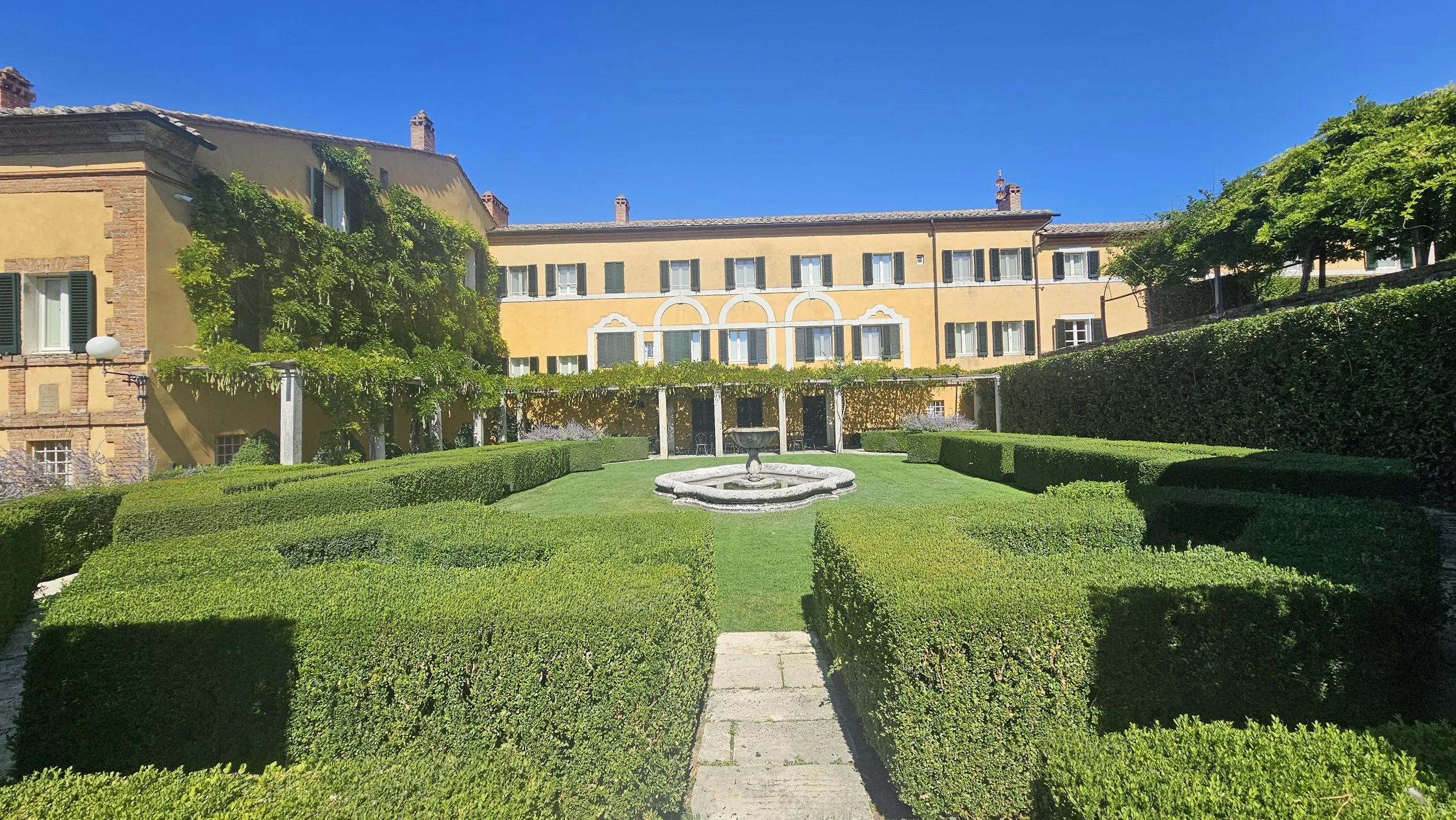 The villa at La Foce above its formal box-hedge garden and fountain, Tuscany