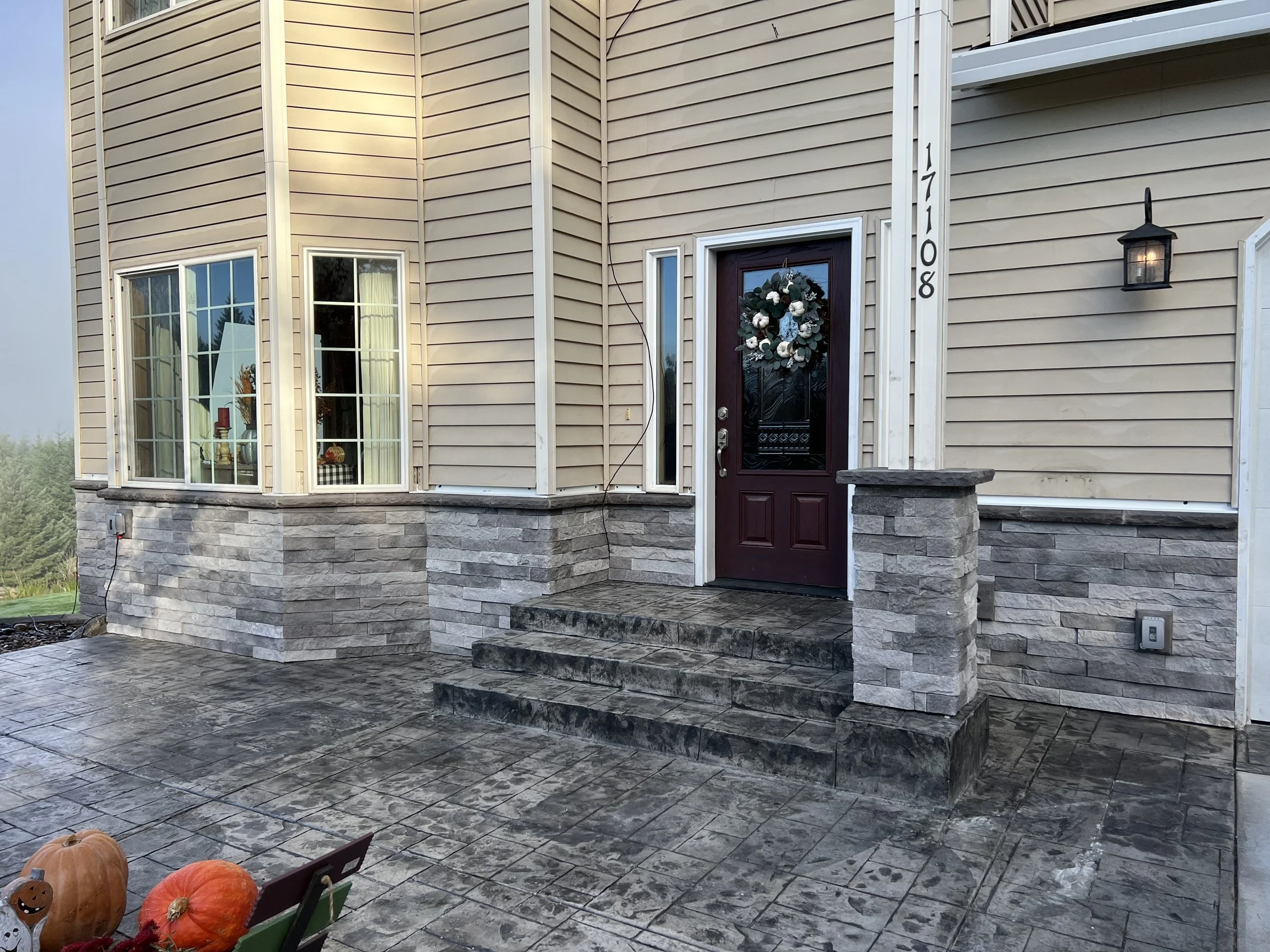 front entrance with stone steps and porch.