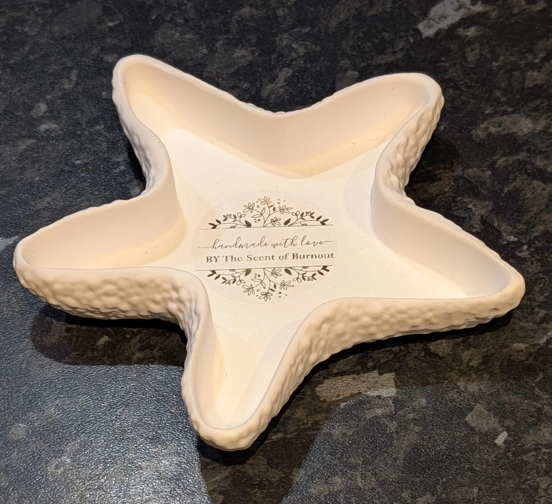 Handmade white eco-stone starfish tray featuring a corporate branding sticker from The Scent of Burnout wellness workshops in London.