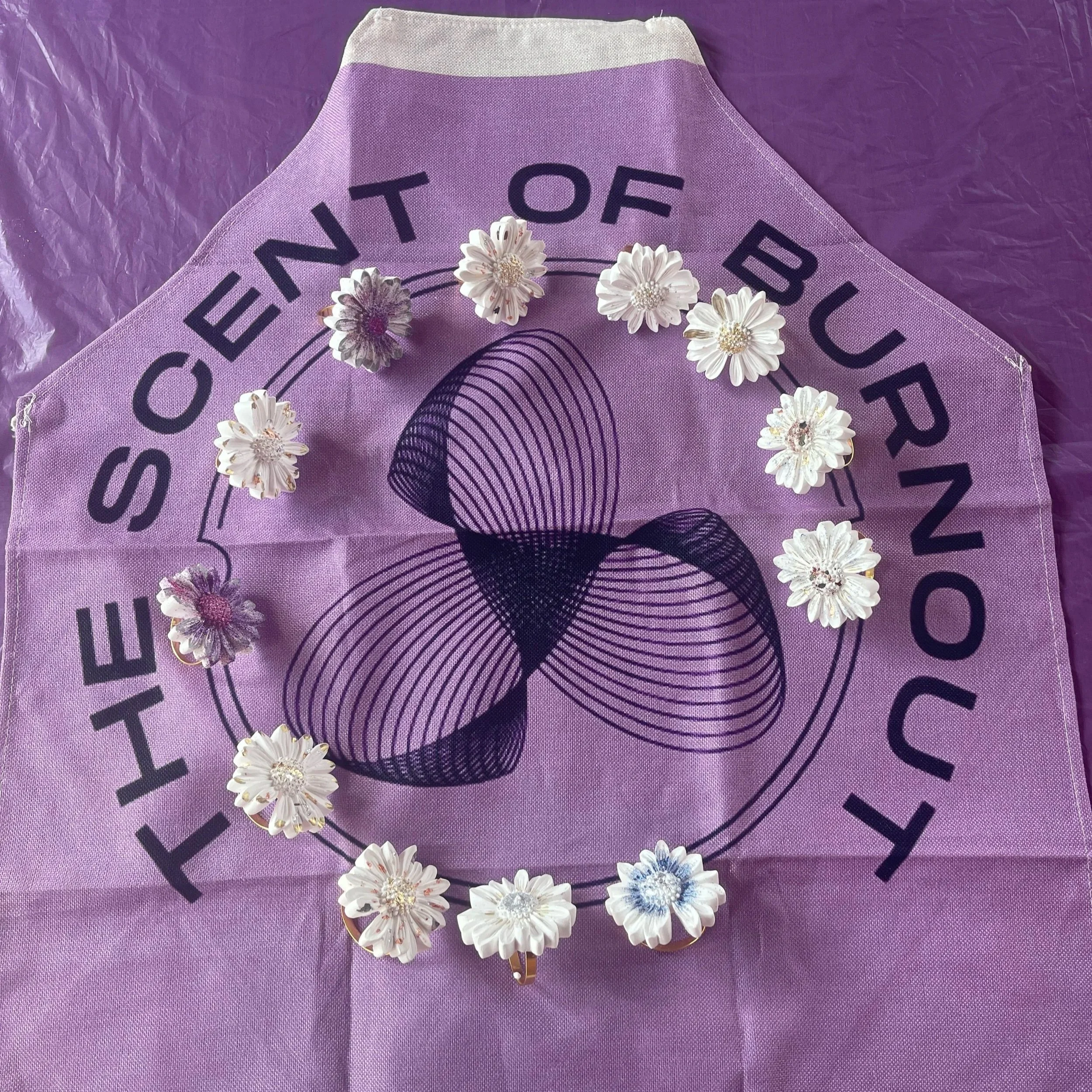 Hand-cast eco-stone daisies arranged on custom branded purple linen for a corporate wellness workshop by The Scent of Burnout in London. Premium sensory team building activities and mindful artisan craft sessions for corporate groups.