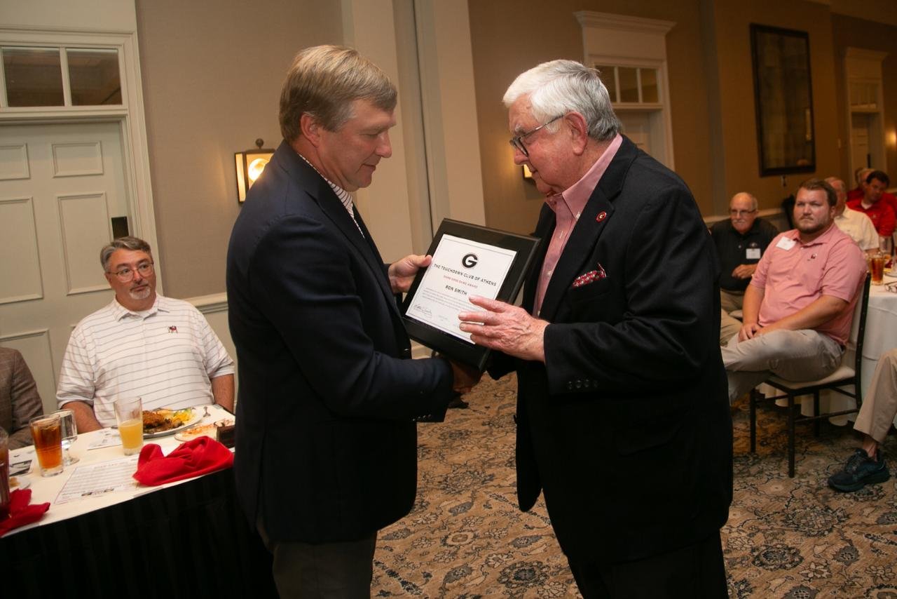 A man receives an award at a formal event.