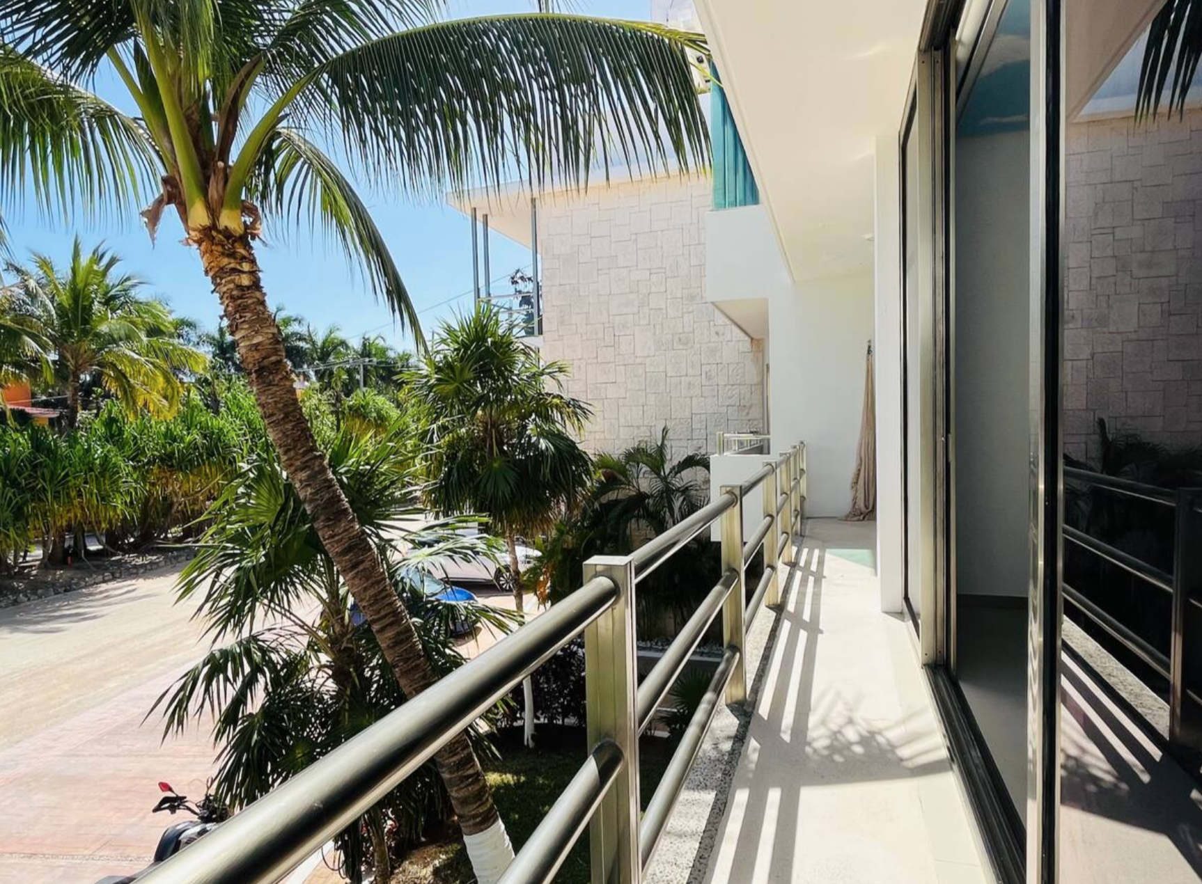 Balcony view with palm trees and modern building exterior