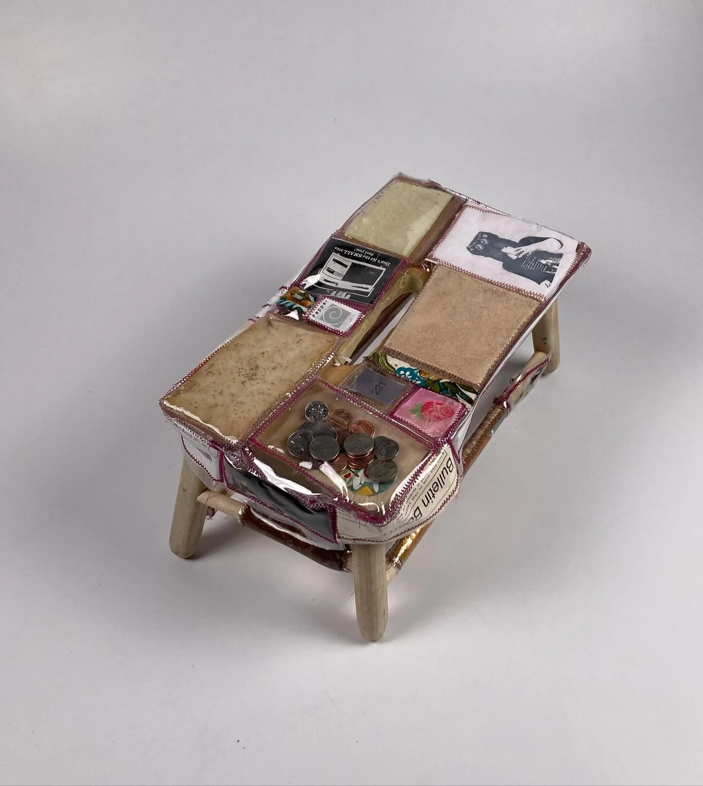Studio Step Stool, 2024.
A simple wooden step stool upholstered with various items and substances from around my studio sewn into clear vinyl patches. Some of the contents include bread, and glitter, a hospital bracelet, a poem, broken machine needle