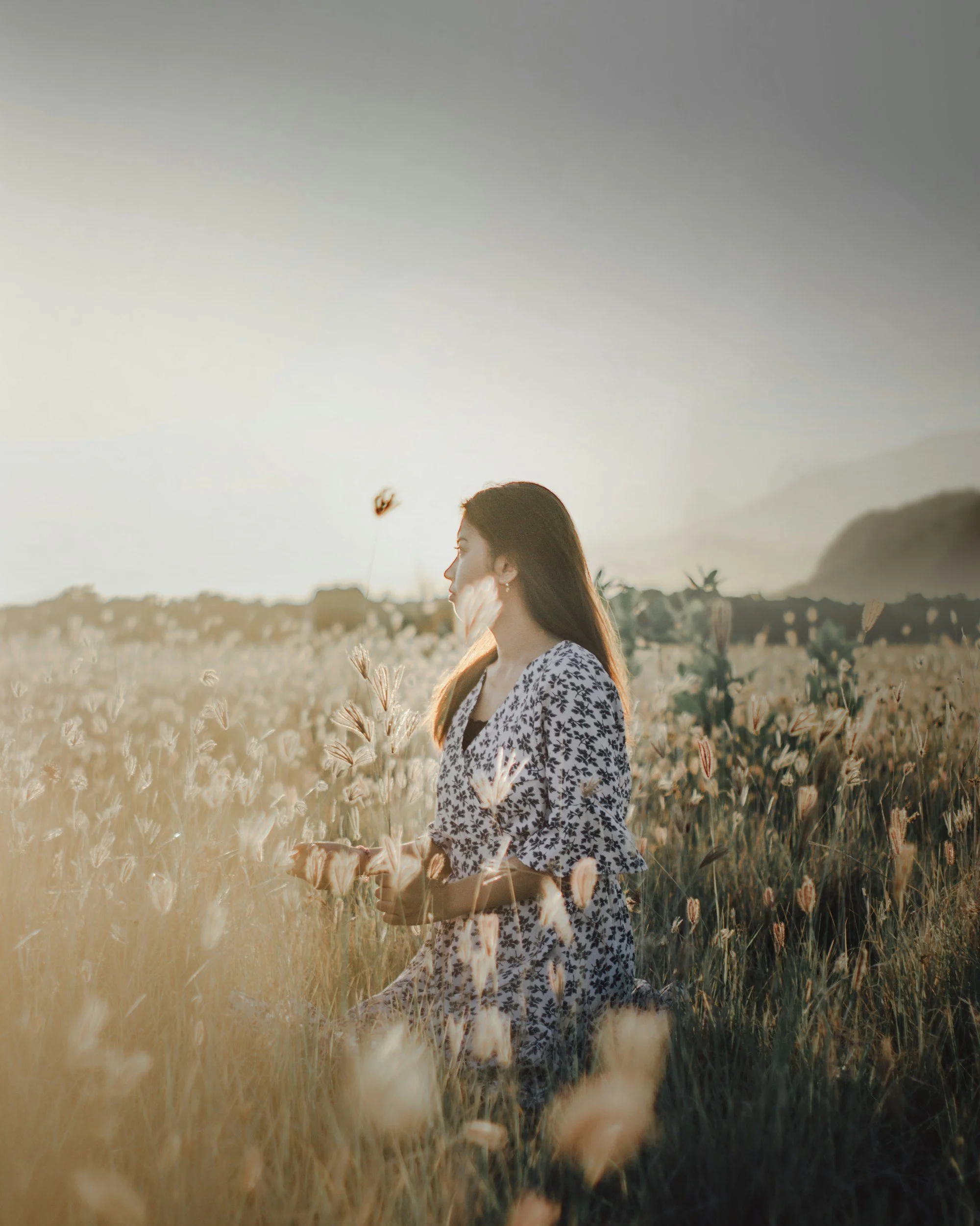 Hand holding a bouquet of flowers and a journal against a bright sky, symbolizing healing, emotional processing, and EMDR therapy support.