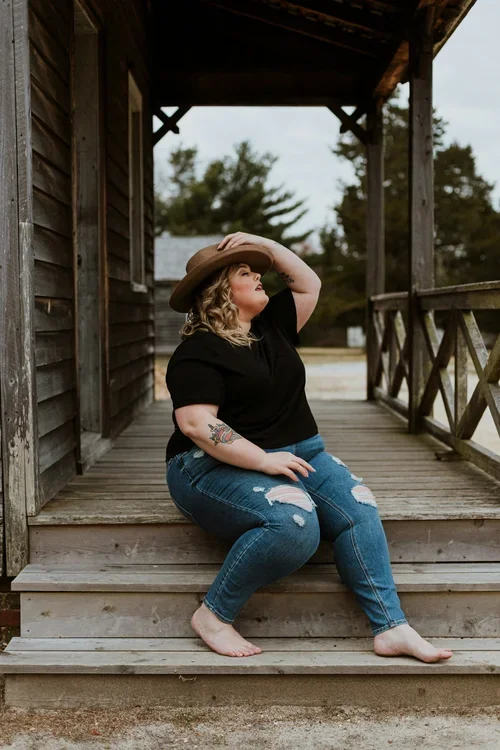 Woman sitting thoughtfully on wooden porch steps outdoors, symbolizing personal growth, change, and support through life transitions therapy.