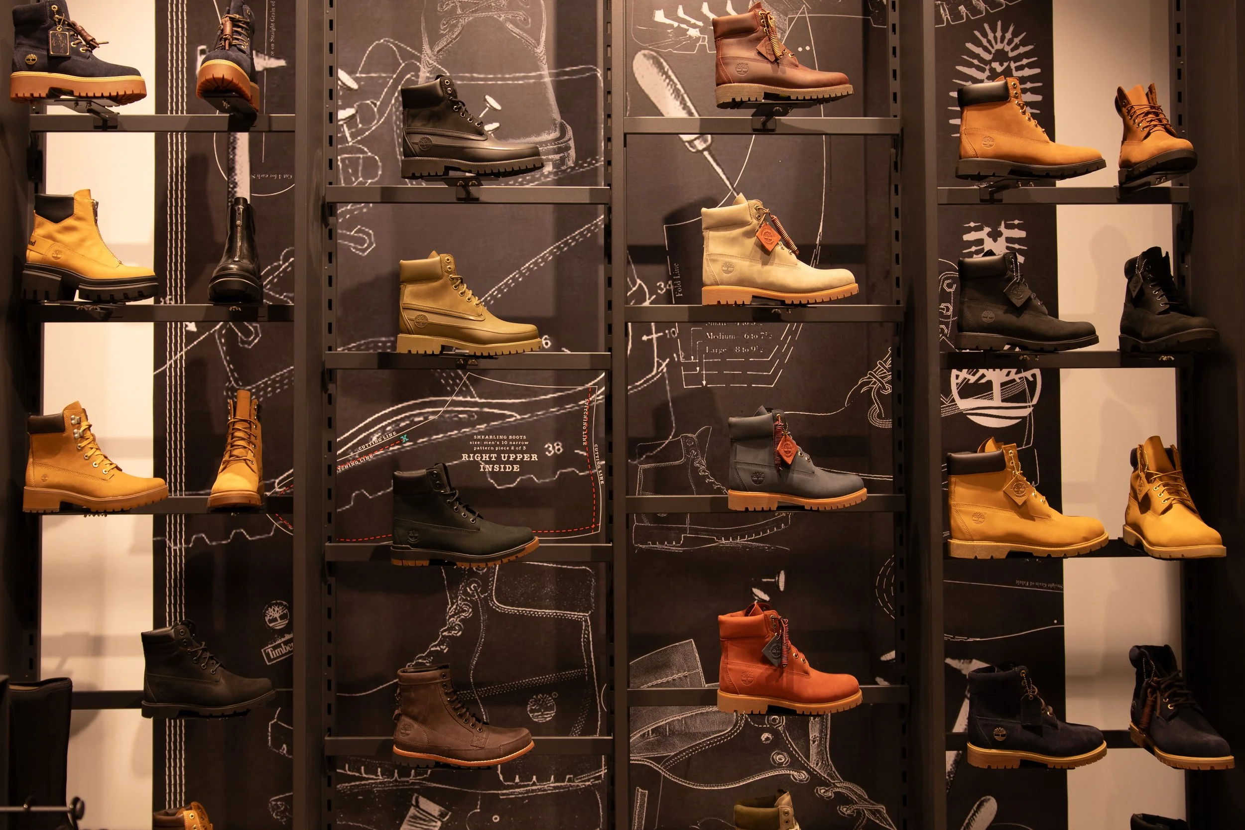 Display of various Timberland boots in different colors on a shelf.