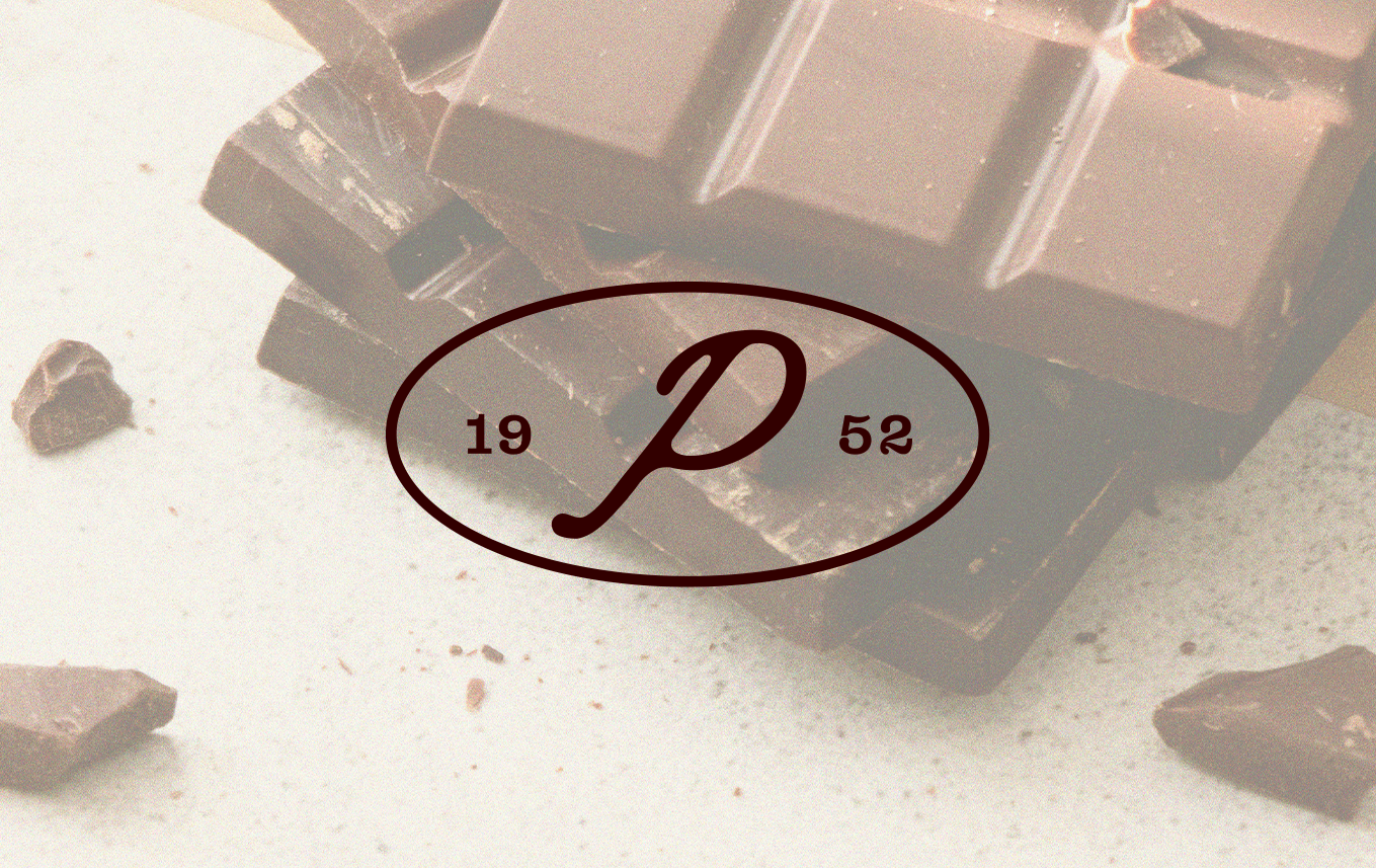 Tablette de chocolat cassée avec des morceaux autour, logo avec la lettre P en cursive et « 19 52 »