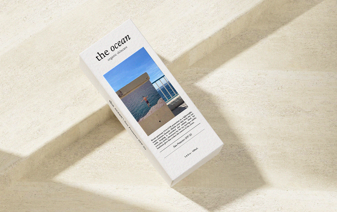 Une boîte de crème solaire portant le nom 'the ocean', avec une photo d'une personne à la mer, à l'extérieur, sous un ciel bleu, et un texte décrivant la protection solaire avec SPF 30.