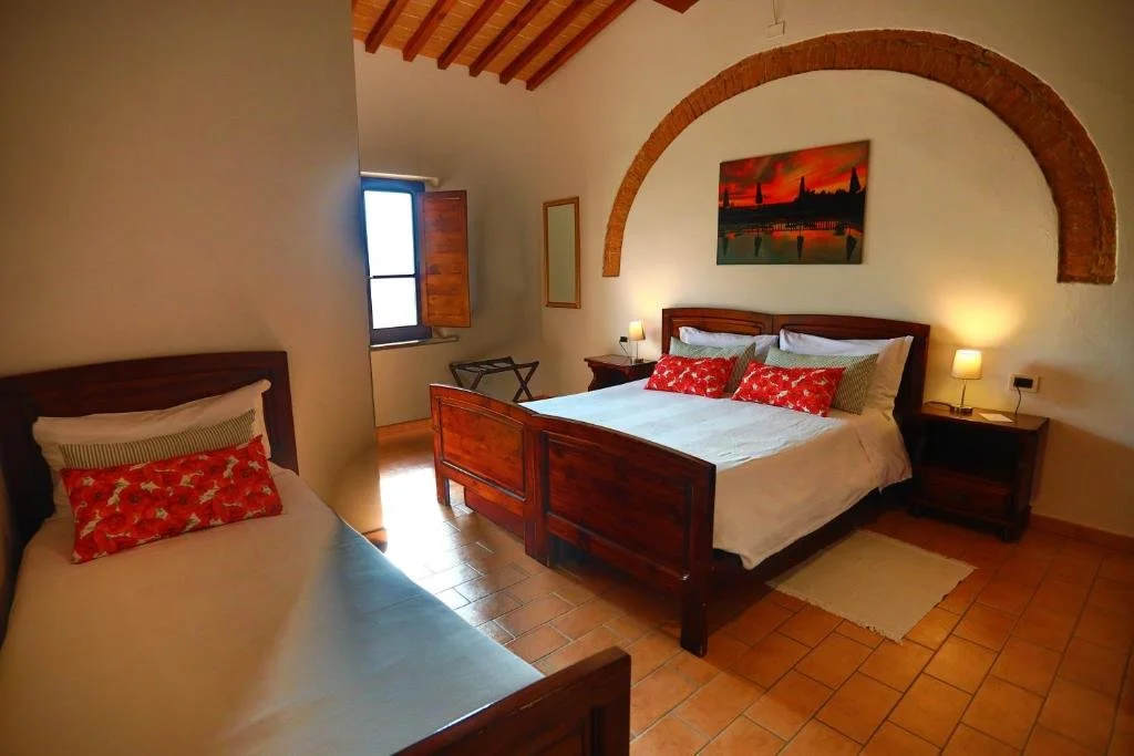 Cozy rustic bedroom with wooden furniture, including bed, nightstands, and wardrobe, and blue bedding.